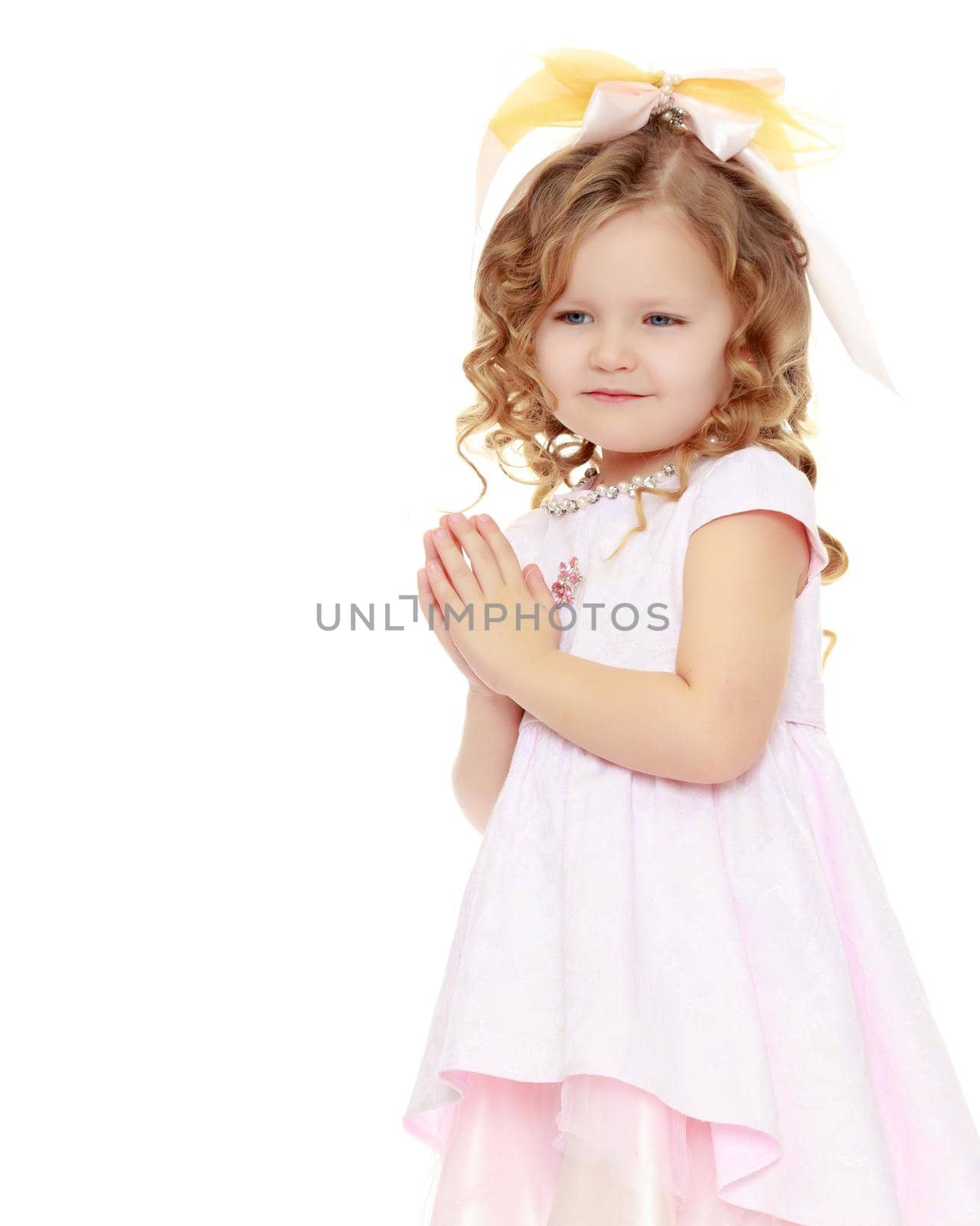 Little boy in black suit with bow tie gives a big red rose charming little girl.Isolated on white background.