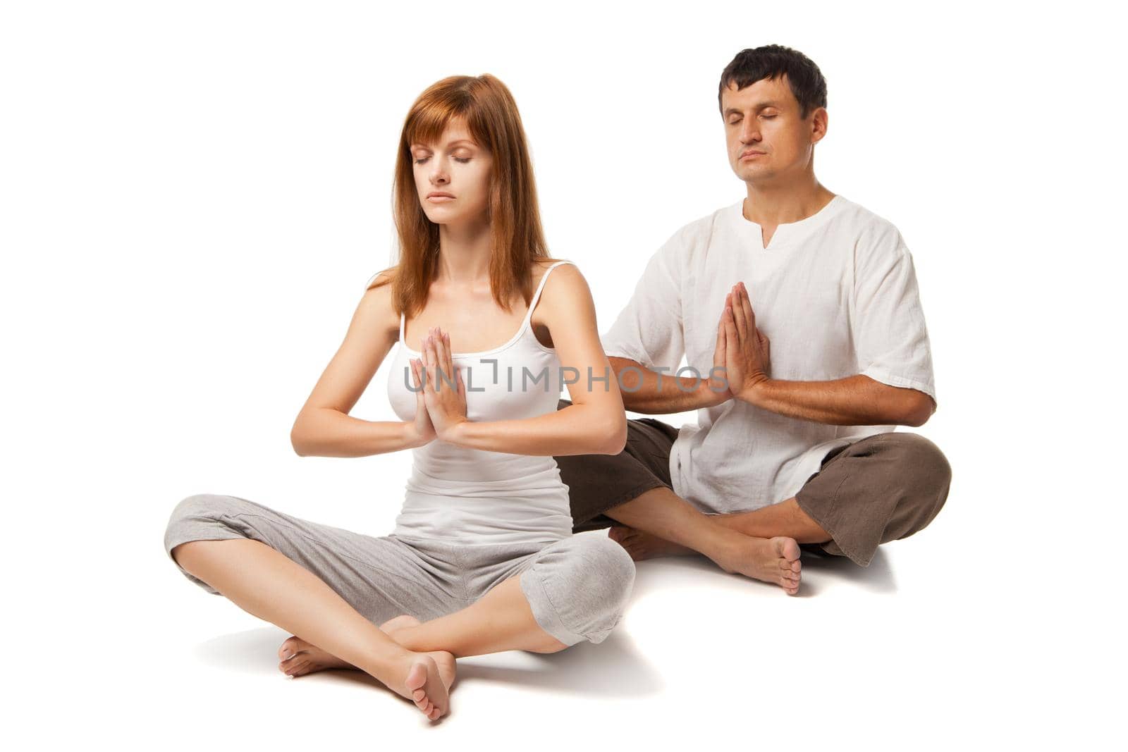 Young healthy couple in yoga position on white background