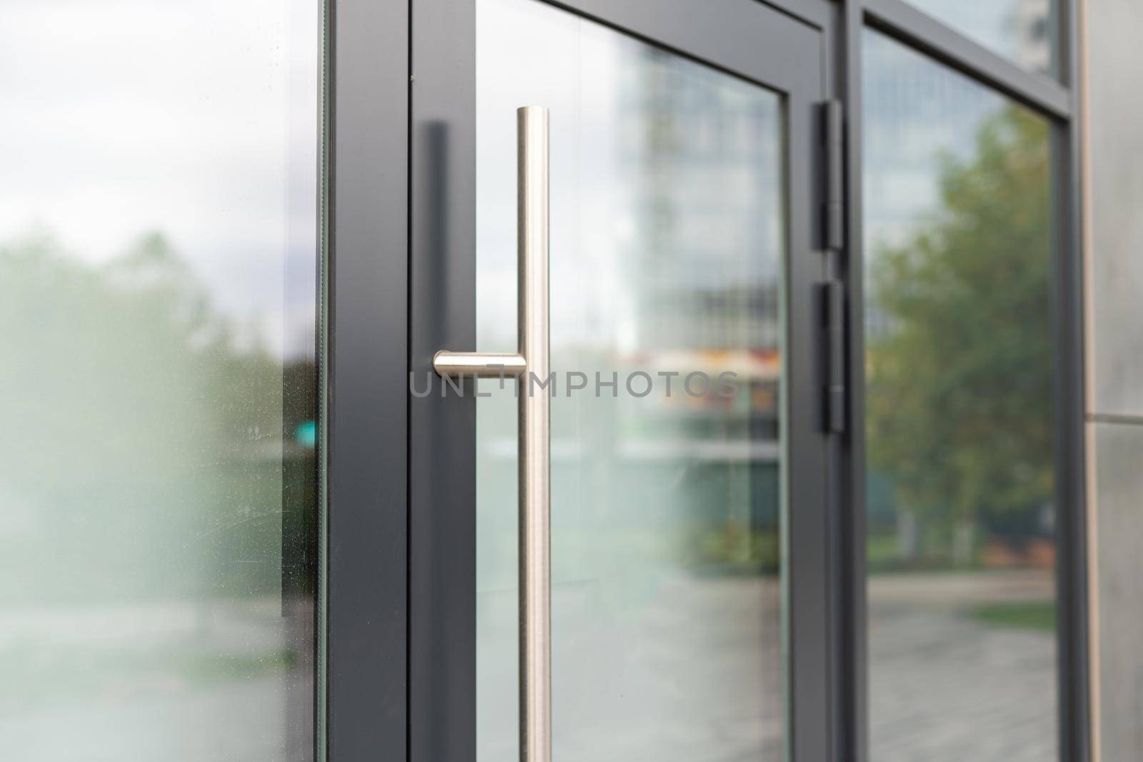 The front door of a office block, reflecting buildings in the glass.