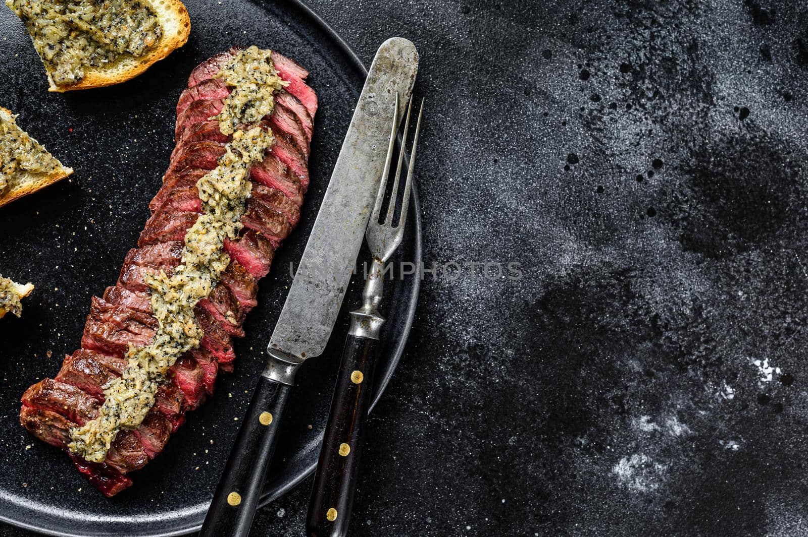 Grilled skirt or machete marble beef steak. Black background. Top view. Copy space by Composter