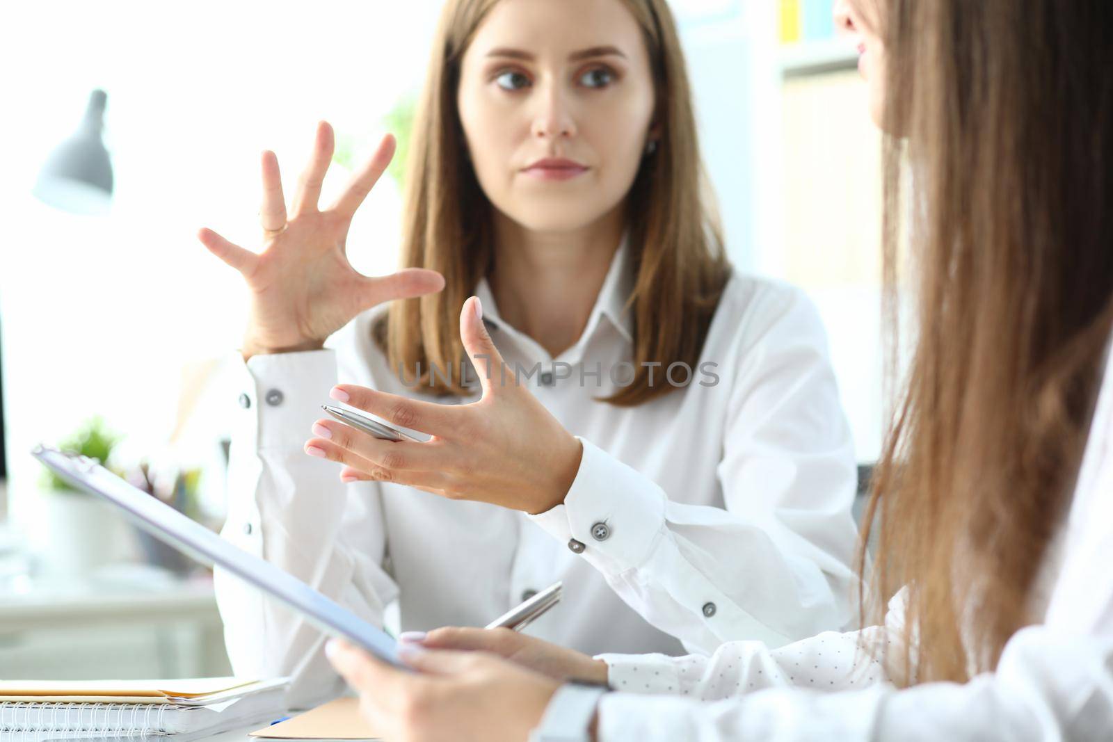 Portrait of concerned businesswoman sitting in modern workplace by kuprevich