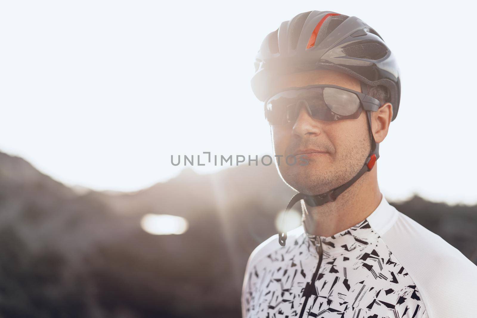 Portrait of male caucasian cyclist with helmet and glasses close up