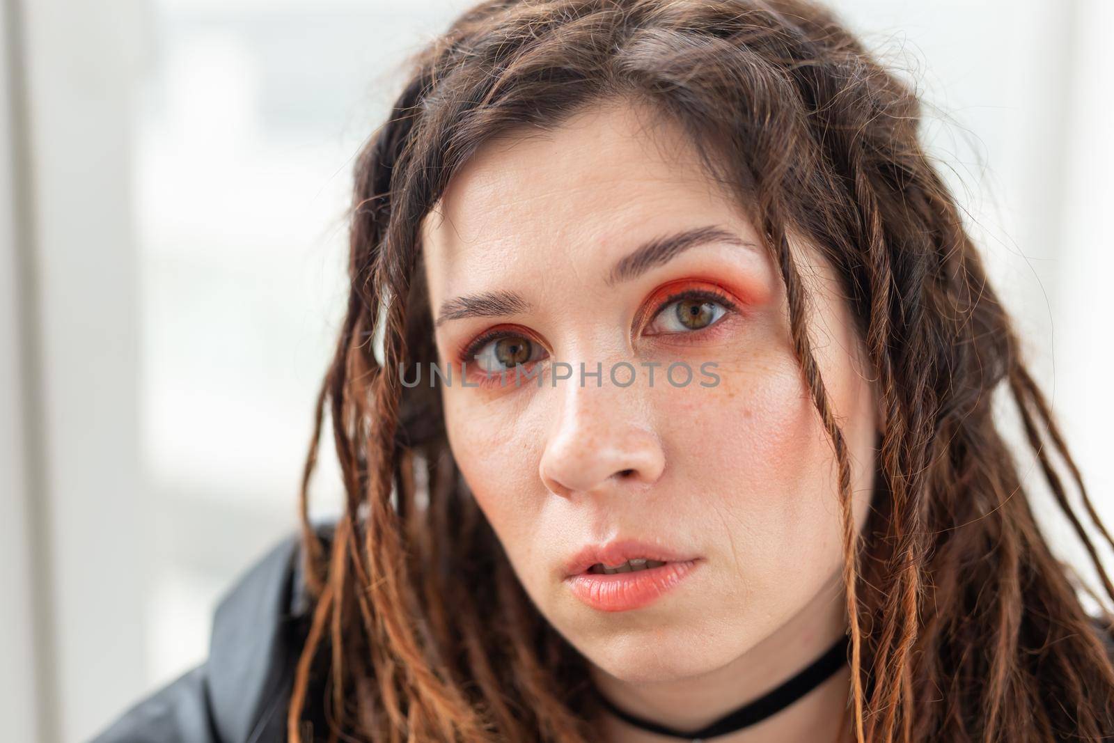 Dreadlocks, hairdresser and style concept - A funny girl with dreadlocks and in leather jacket and fashionable makeup.