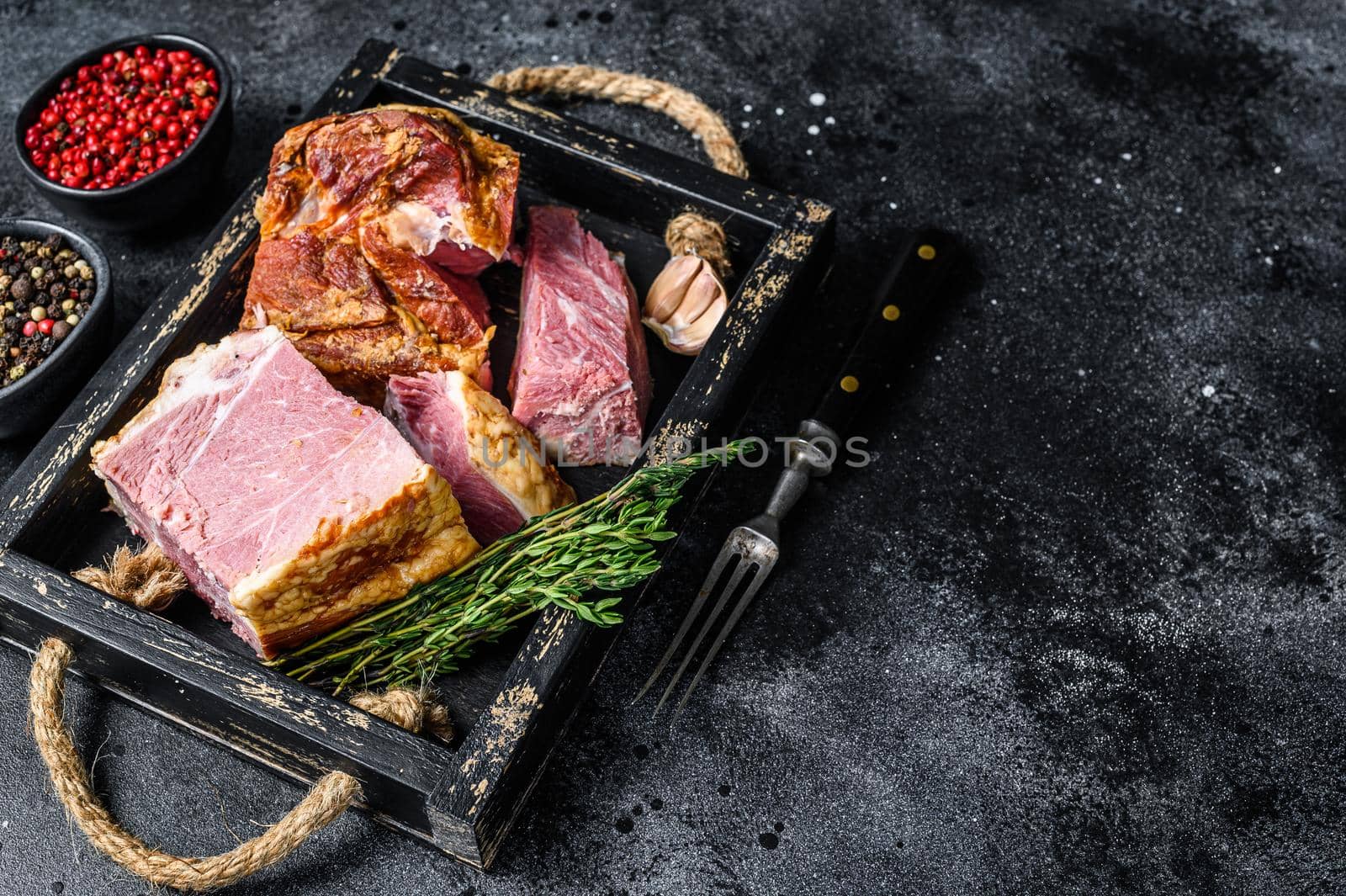 Smoked Sliced Pork Slab Bacon Meat in a wooden tray. Black background. Top view. Copy space by Composter