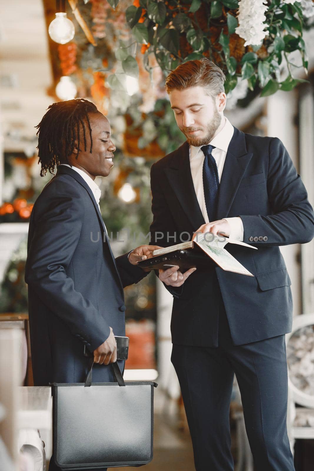 African man. Guy in a black suit. Mixed people work together.