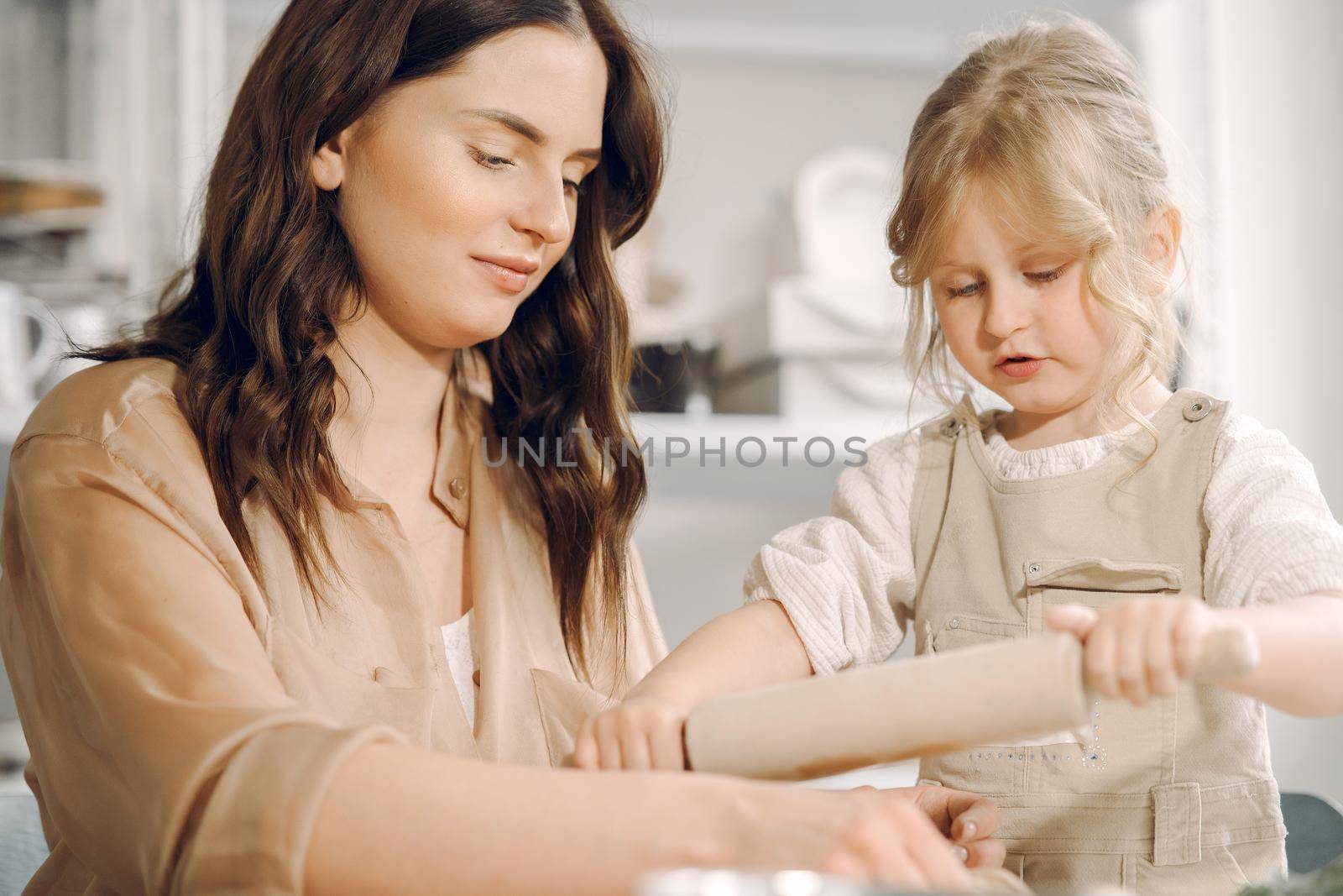 Woman and girl kneading clay. Family make art product at table in pottery workshop. Mother with daughter.