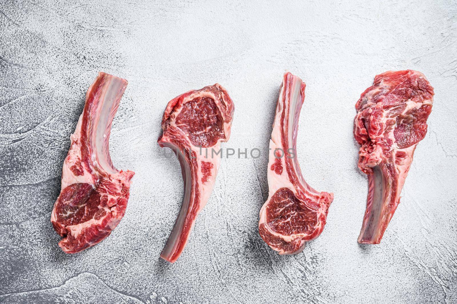 Raw lamb meat chops on a butcher table. White background. Top view.
