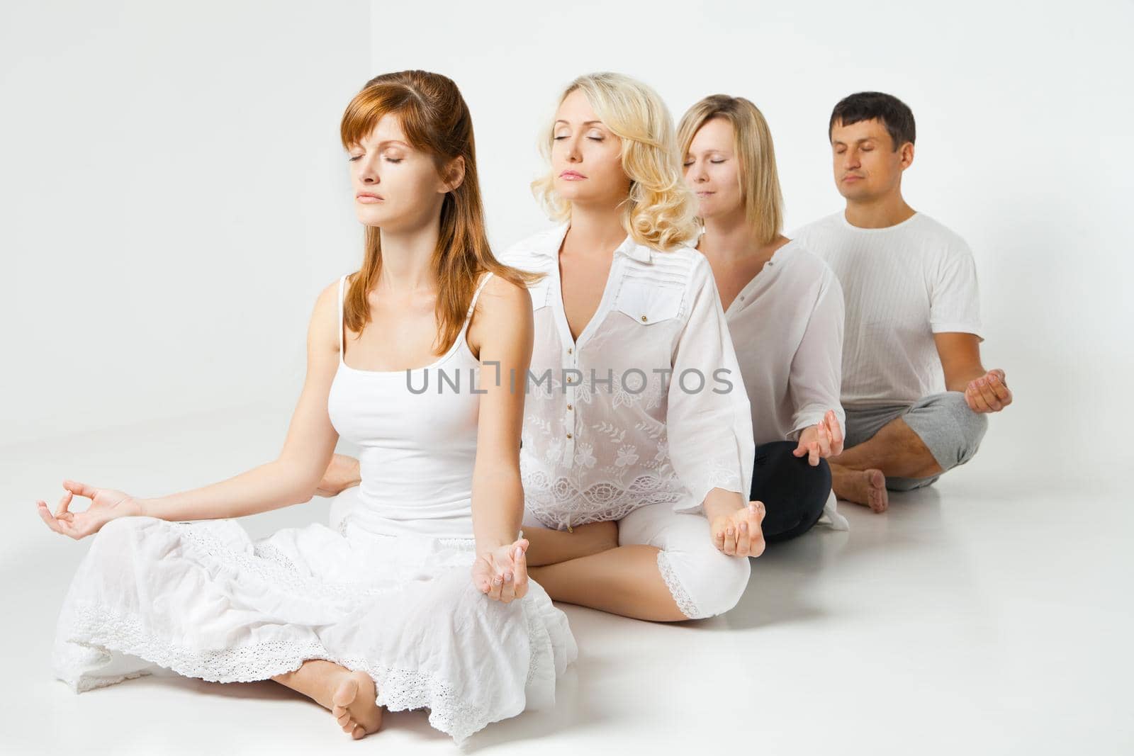 Group of people relaxing and doing yoga in white by Julenochek