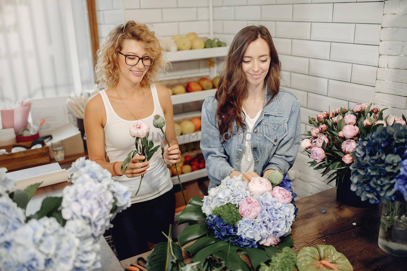 Girls with a flowers. Florist making a bouquet