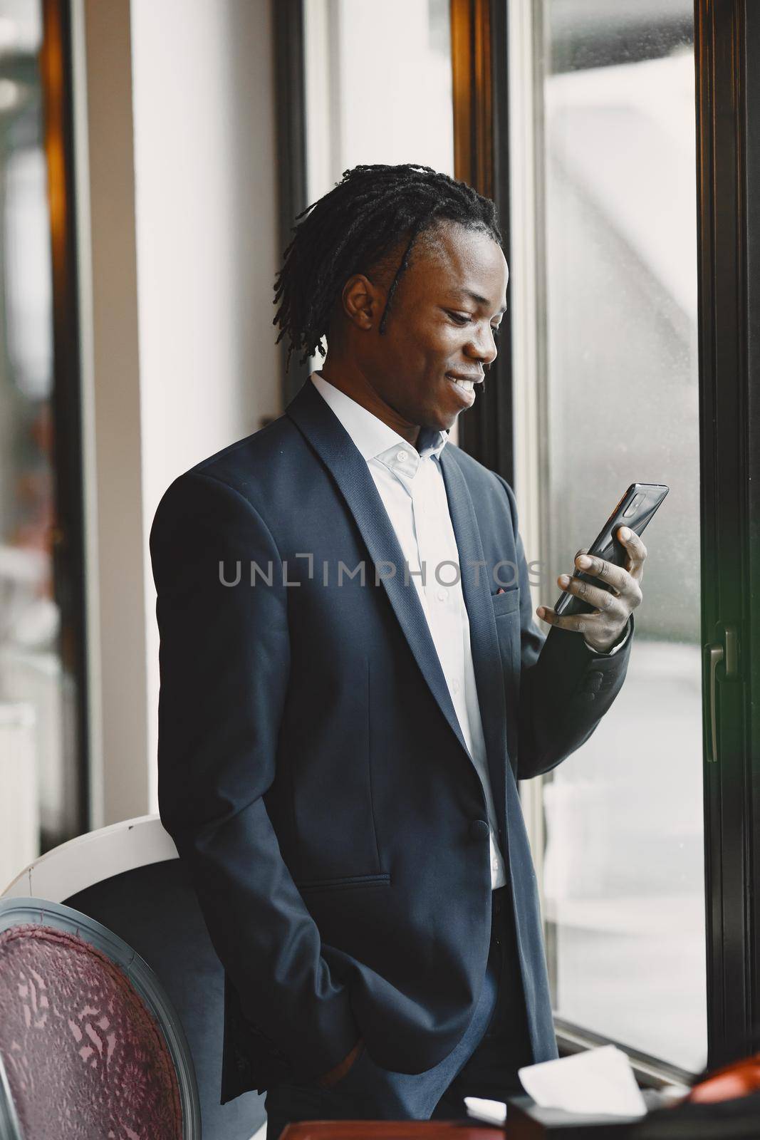 Handsome african man in a black suit at the office by prostooleh