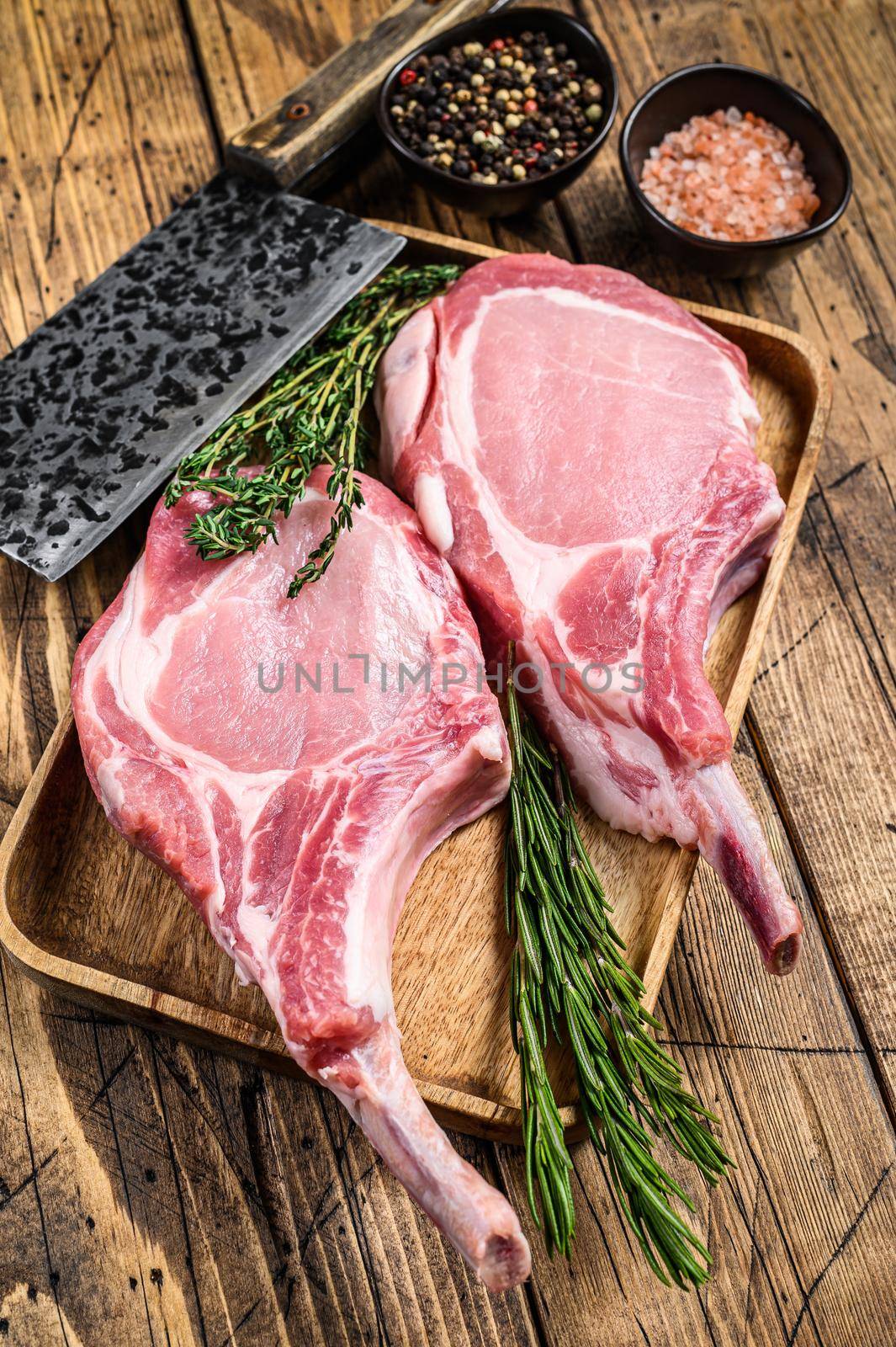Fresh raw pork loin chops with pepper and salt. wooden background. Top view by Composter