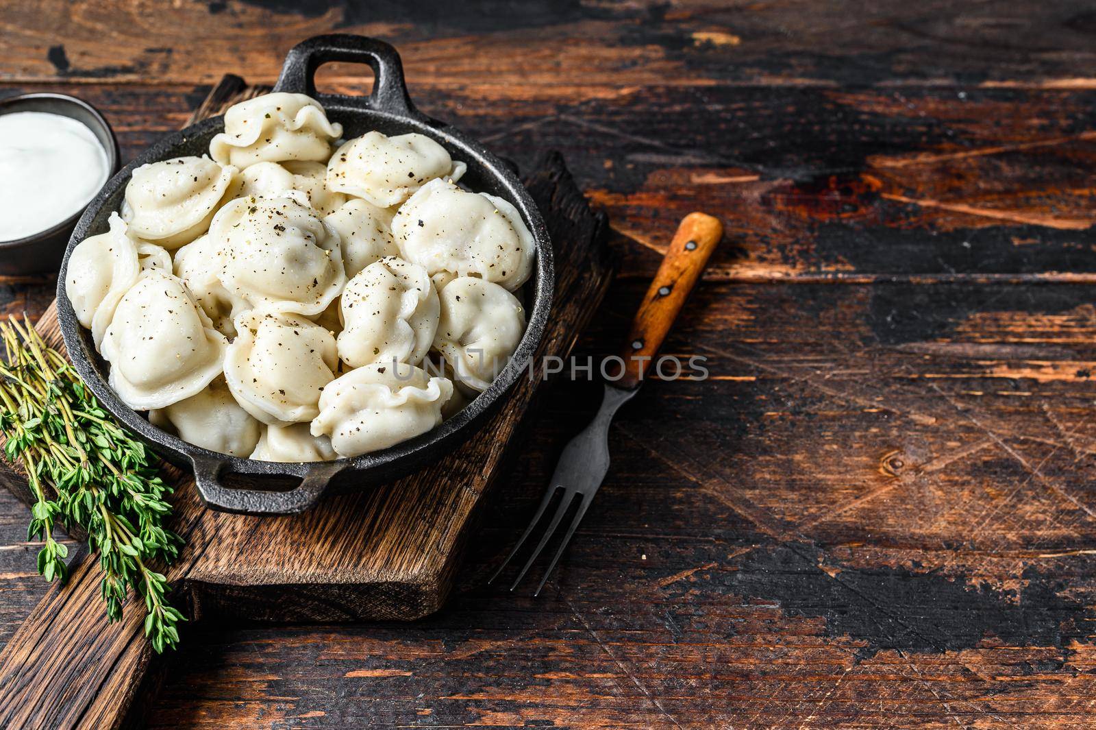 Russian Dumplings Pelmeni with beef and pork meat. Dark wooden background. top view. Copy space by Composter