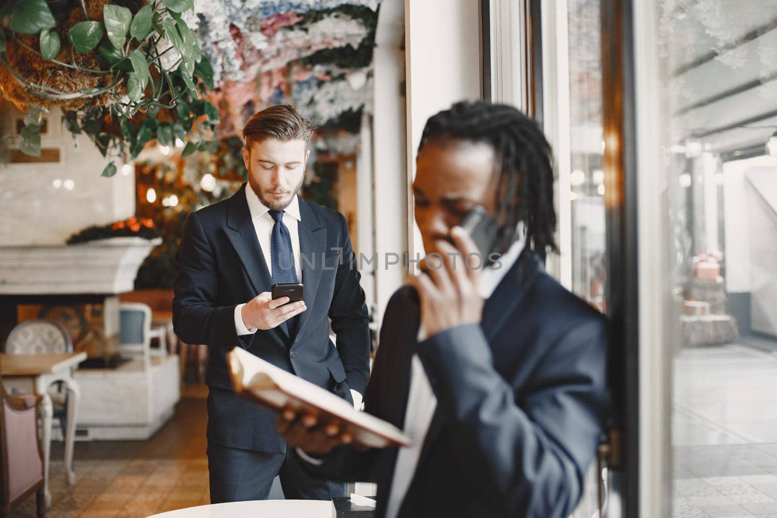 African man. Guy in a black suit. Mixed people work together.