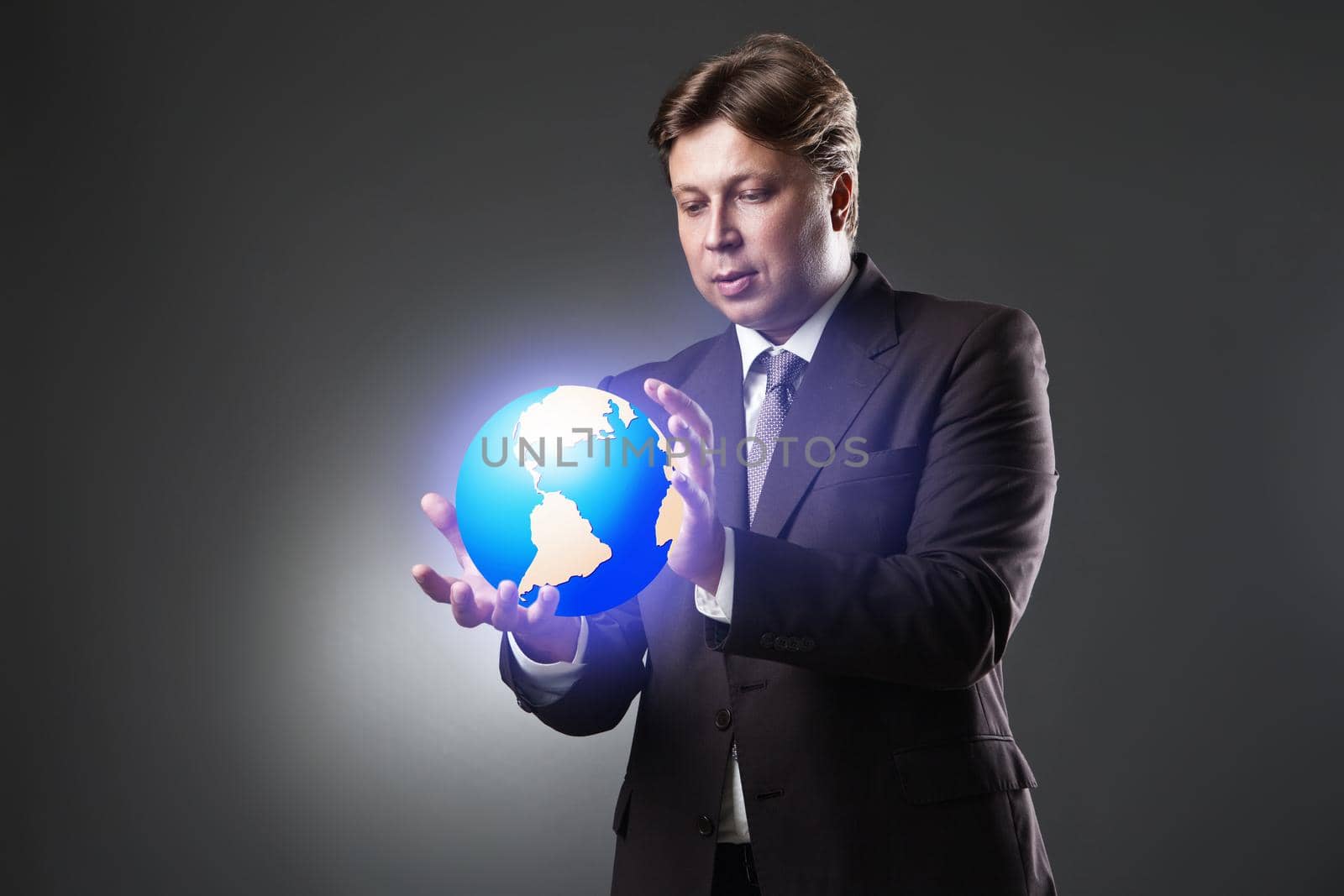 Hand of Business Man Hold Earth Globe on dark by Julenochek