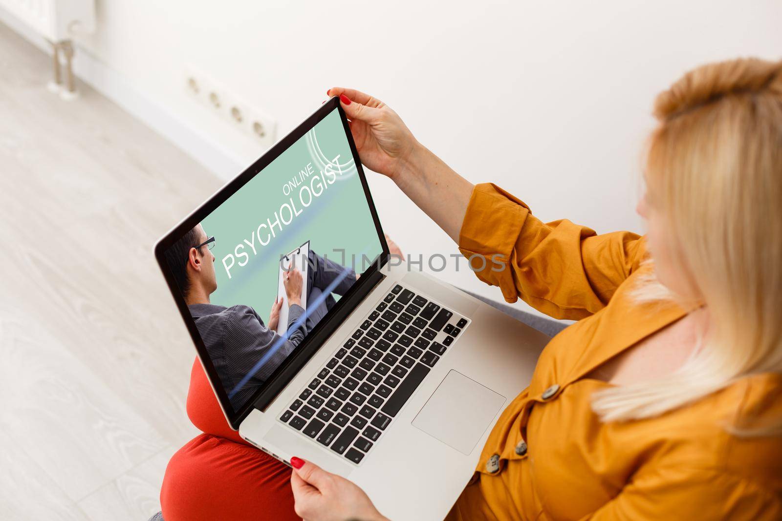 Woman in front of her laptop having an online call with her therapist, text space by Andelov13