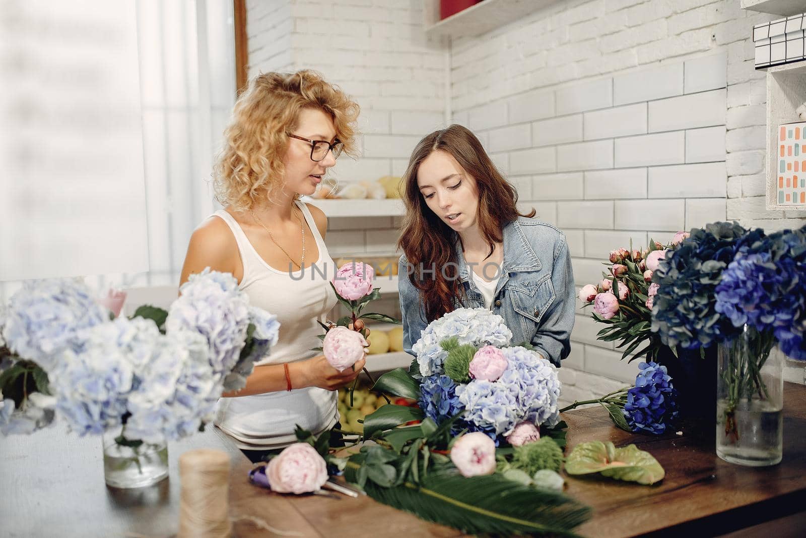 Girls with a flowers. Florist making a bouquet