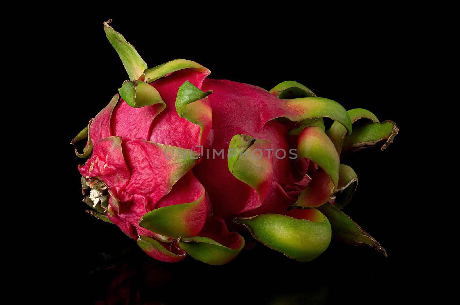 Dragon fruit horizontally on a black background with reflection