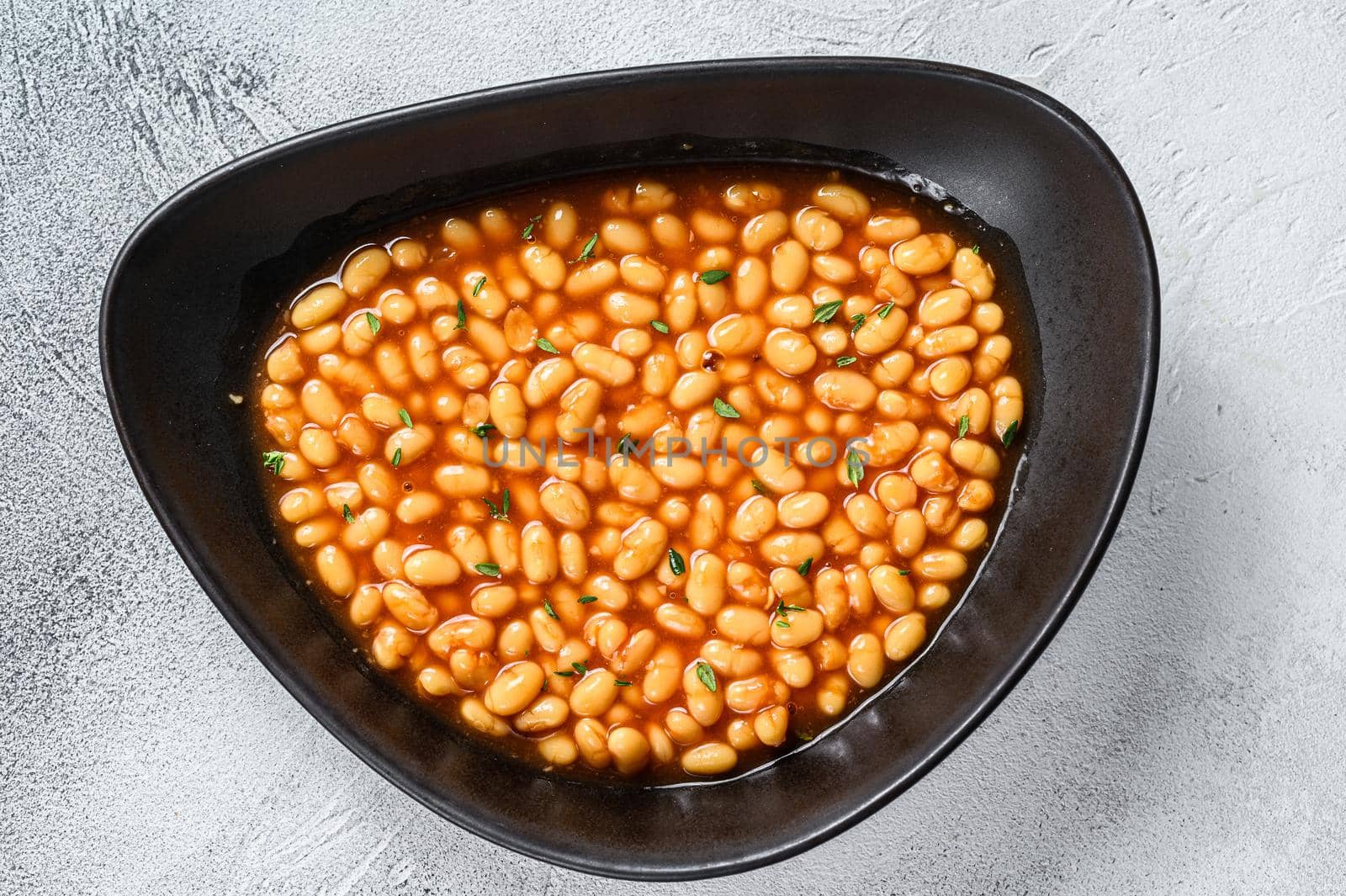 Baked beans in tomato sauce in a plate. White background. top view.