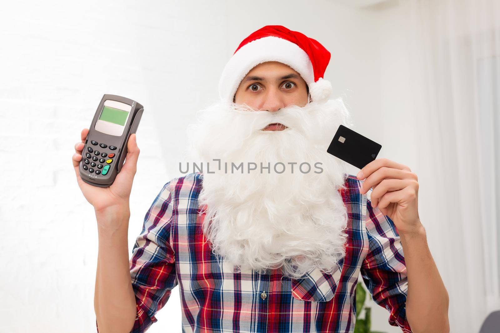 Portrait of his he nice attractive Santa holding in hand bank card digital terminal system commerce trade