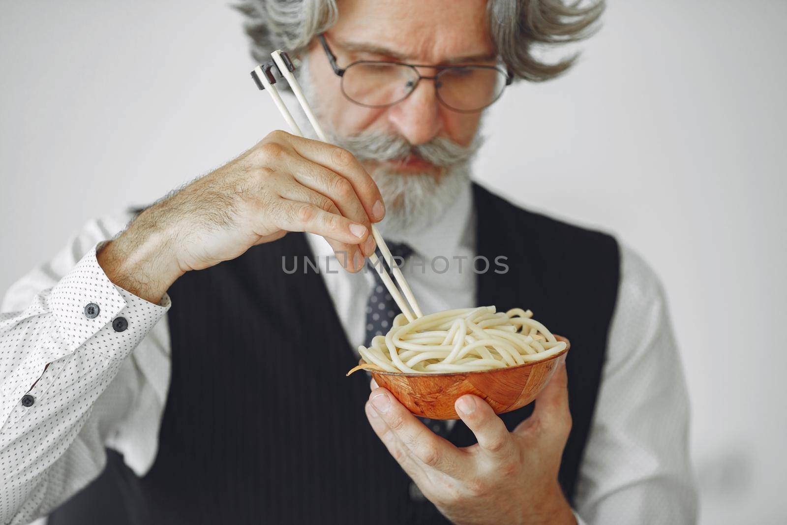 Lunch break. Elegant man in office. Businessman in white shirt. Man eats noodles.