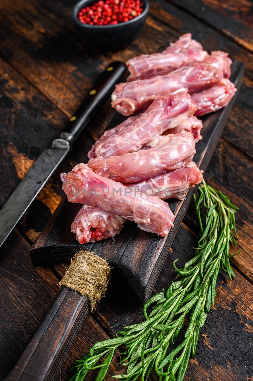 Chicken neck meat on a cutting board. Wooden background. Top view.