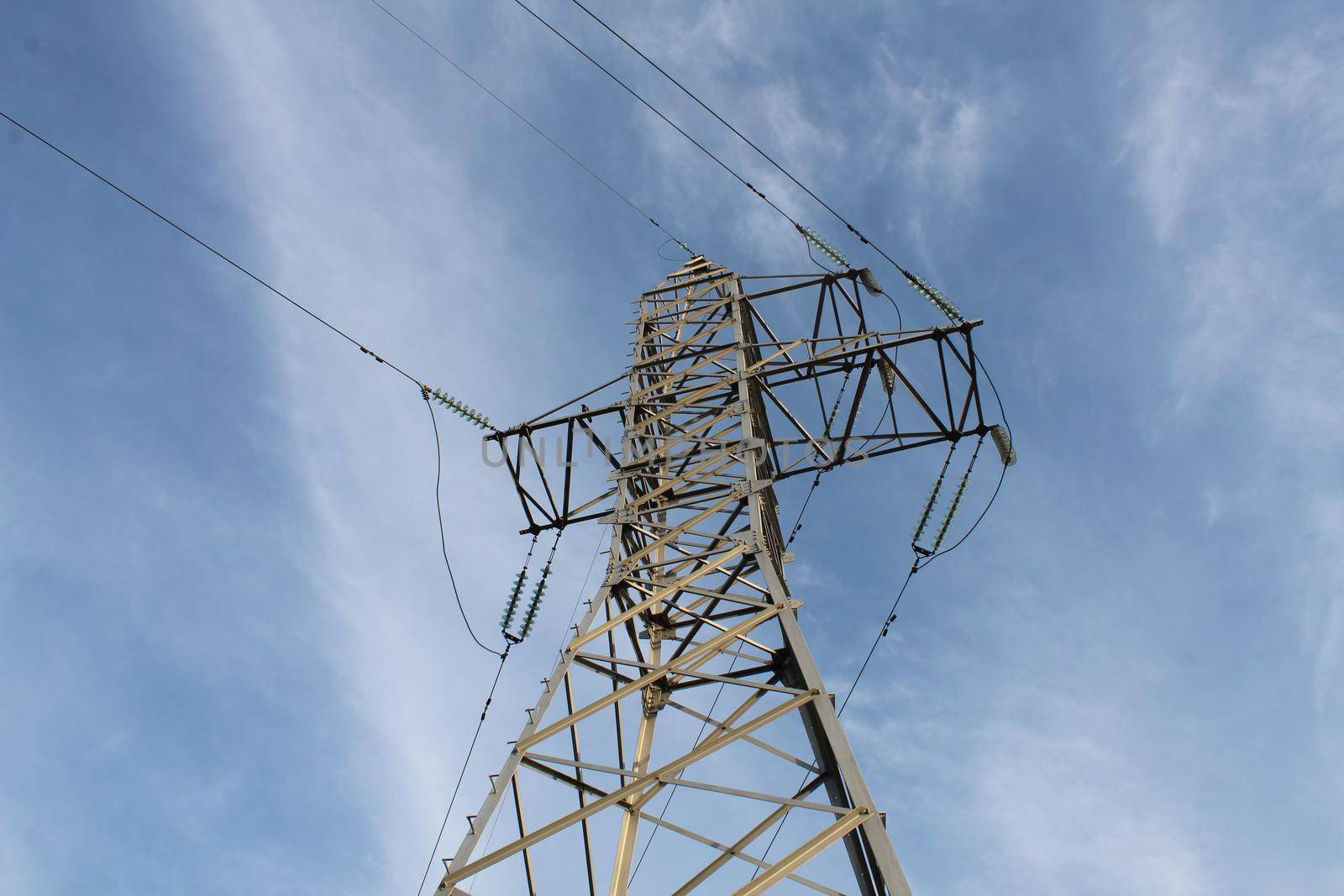 high-voltage tower against a blue sky with a place for text.