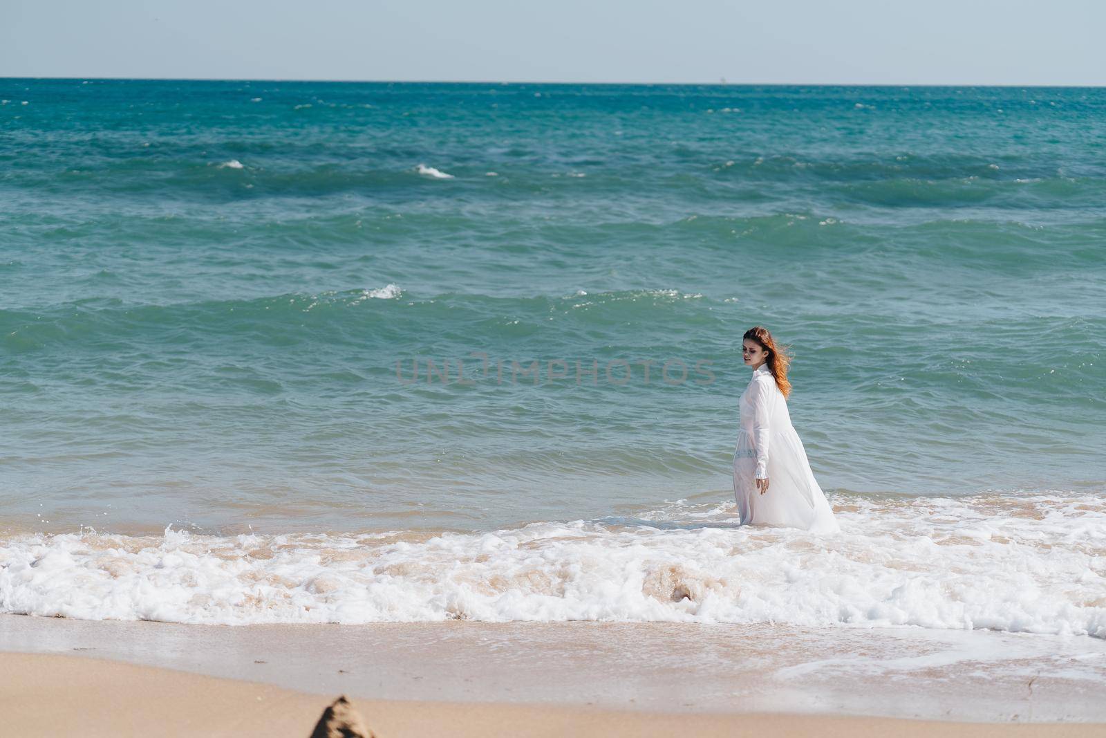 Woman in white dress freedom walk on ocean island. High quality photo