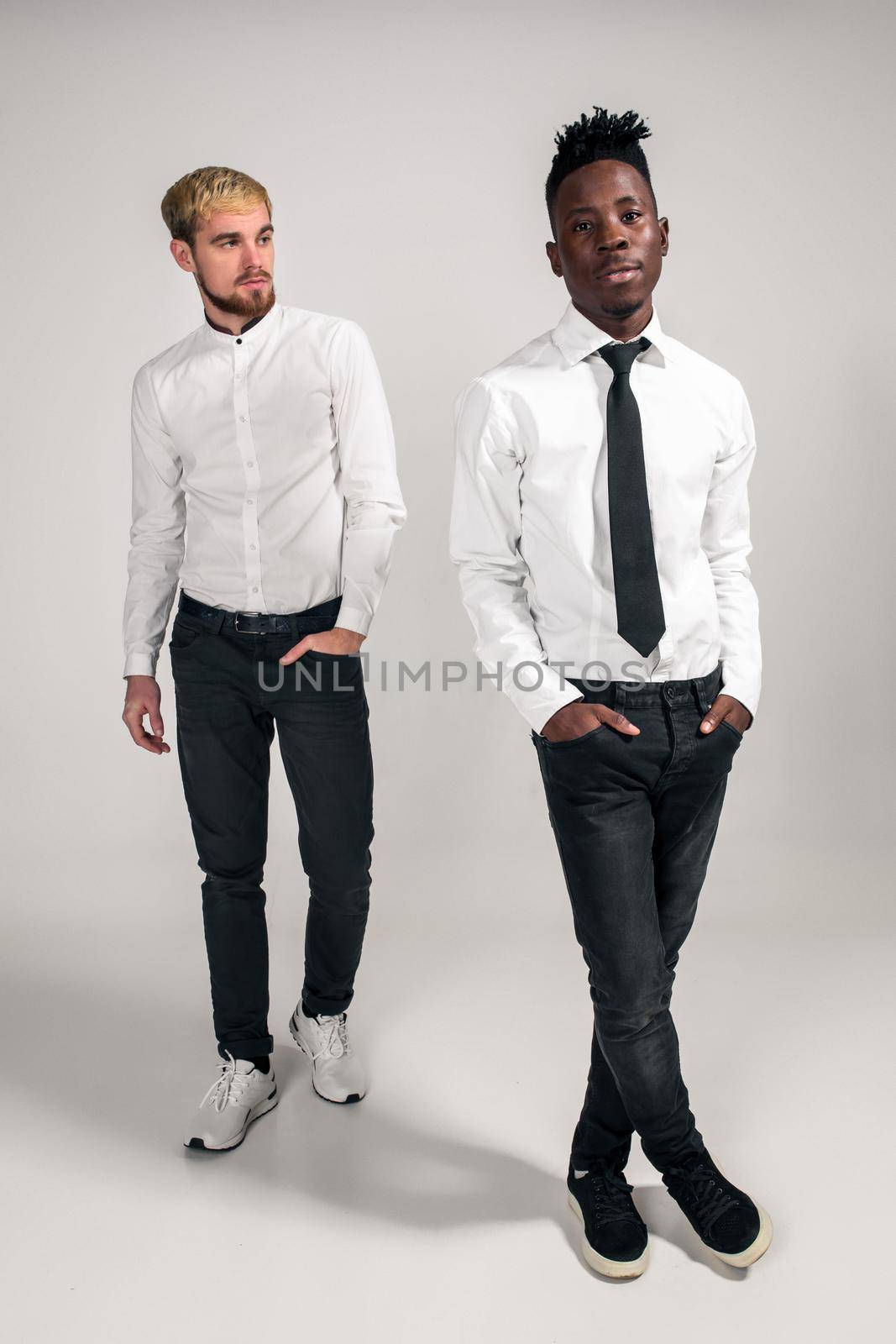 International friendship concept. Studio shot of two stylish young men on white background by nazarovsergey