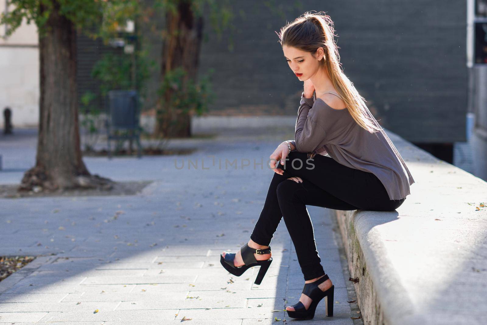 Portrait of beautiful blonde girl in urban background