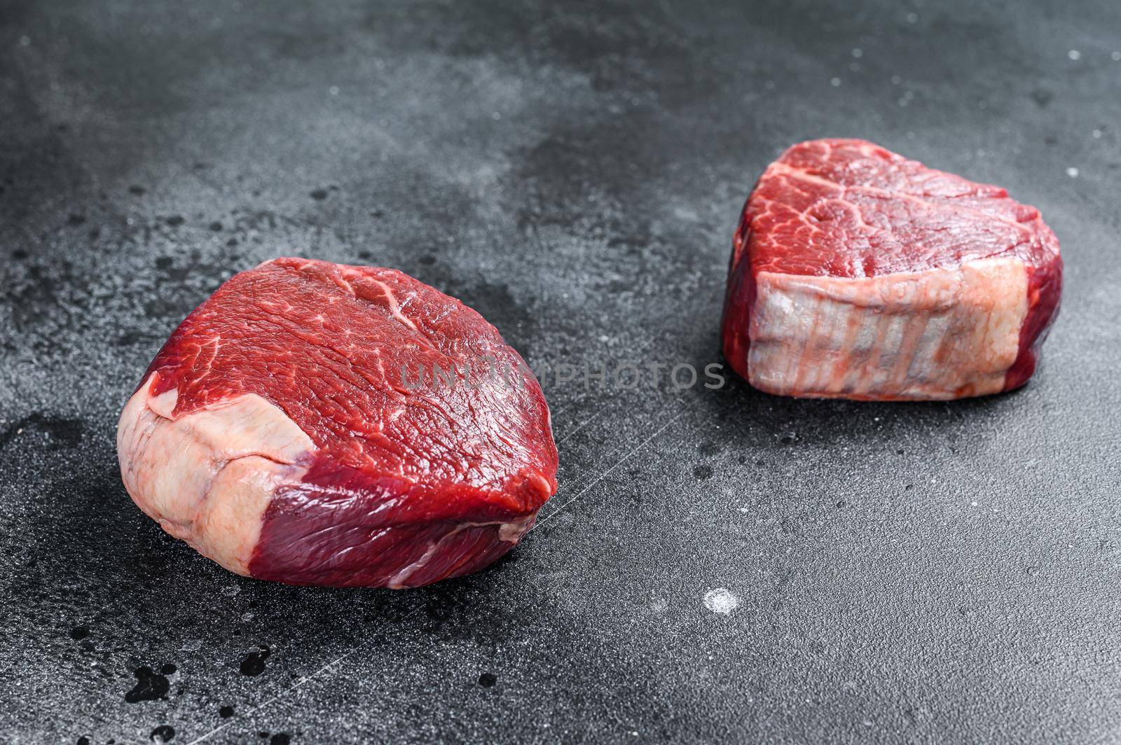 Raw beef meat steak Tenderloin fillet. Black background. Top view.