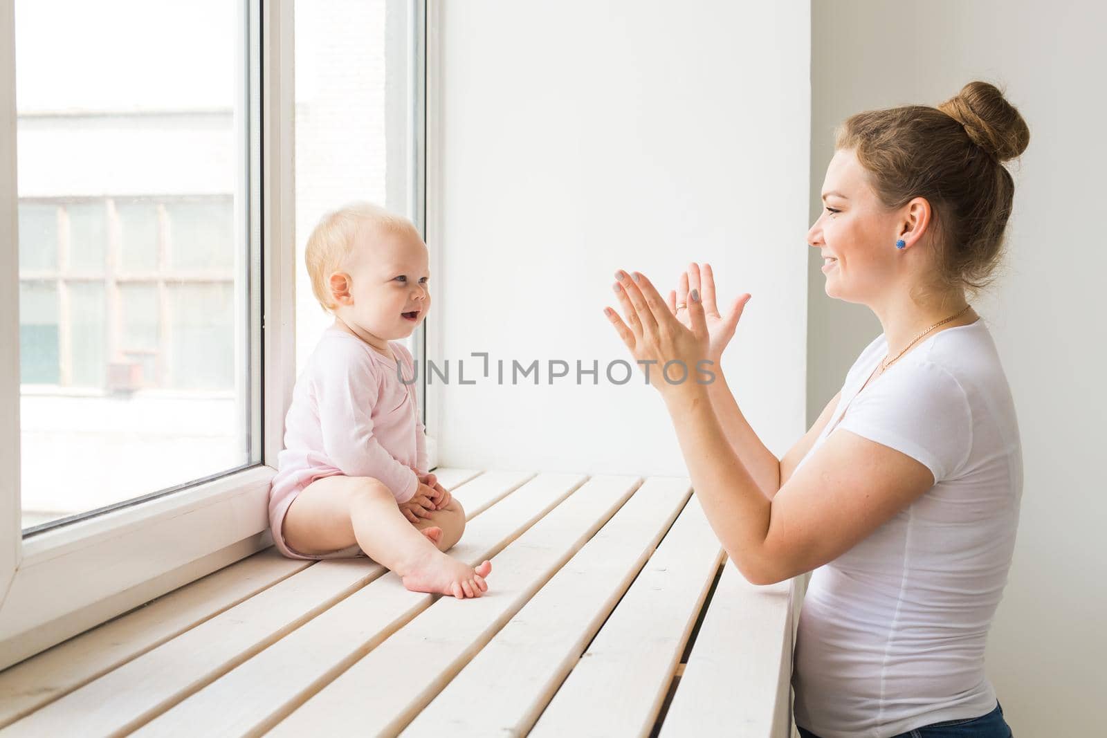 Childhood, family and motherhood concept - Mother with her baby playing at living room.