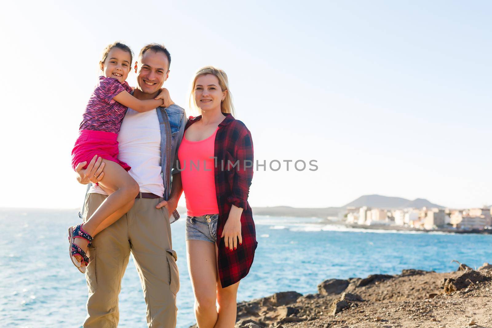 Family holiday on Tenerife, Spain. Mother with children outdoors on ocean. Portrait travel tourists - mom with kids. Positive human emotions, active lifestyles. Happy young family on sea beach by Andelov13