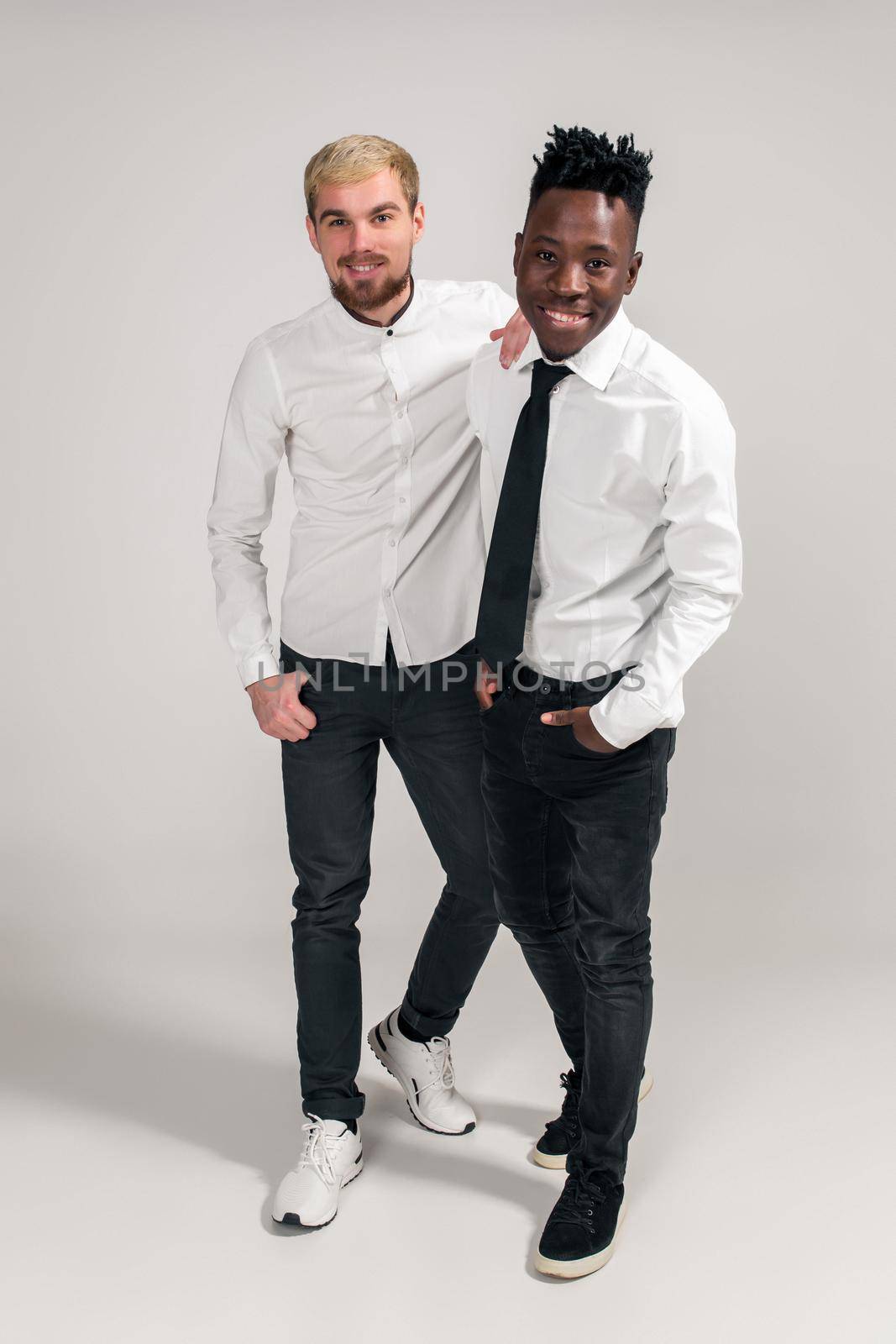 International friendship concept. Studio shot of two stylish young men on white background by nazarovsergey