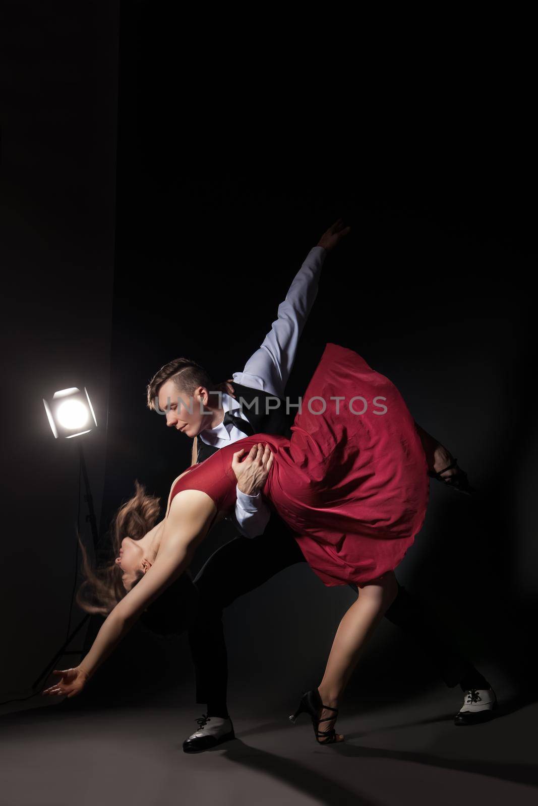 Man and woman in the most romantic dance tango over dark background