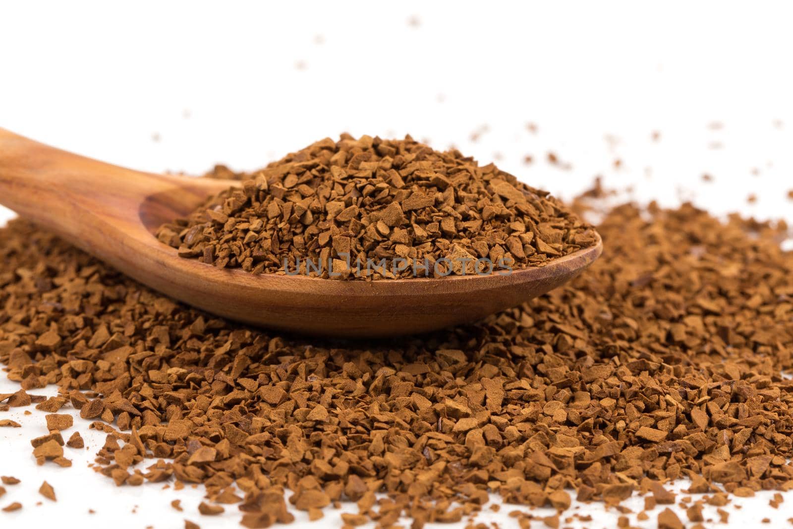 Heap of instant coffee in spoon isolated on white background