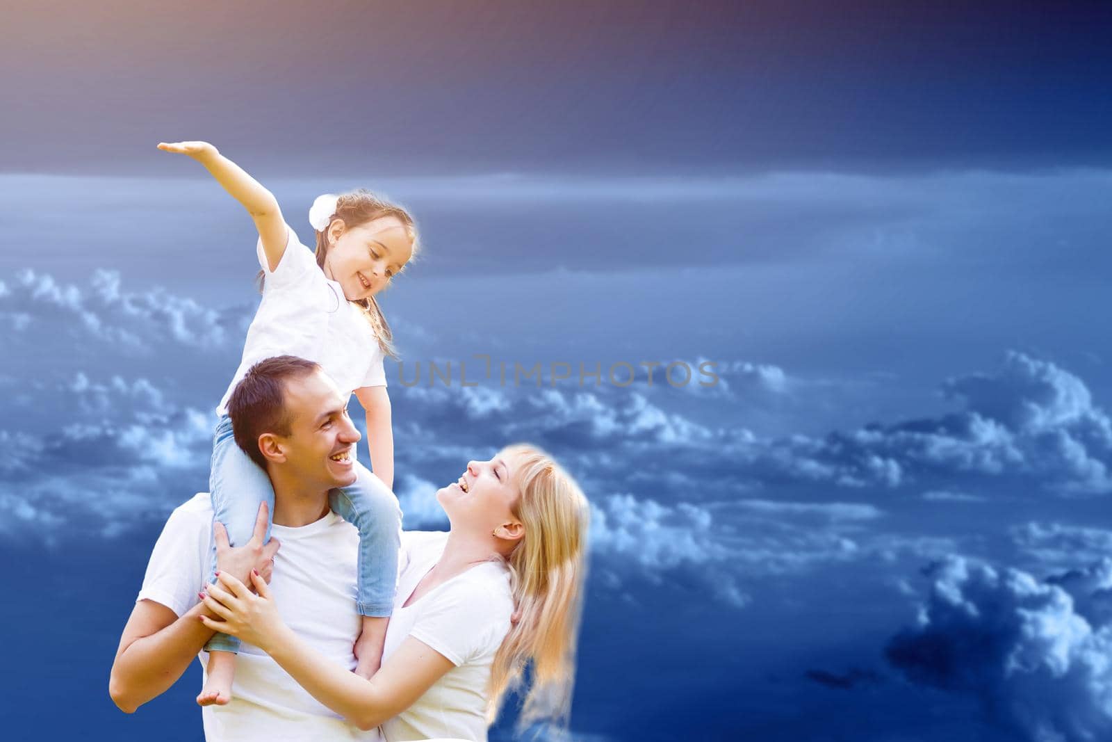 young happy family having fun outdoors, dressed in white and with blue sky in background by Andelov13