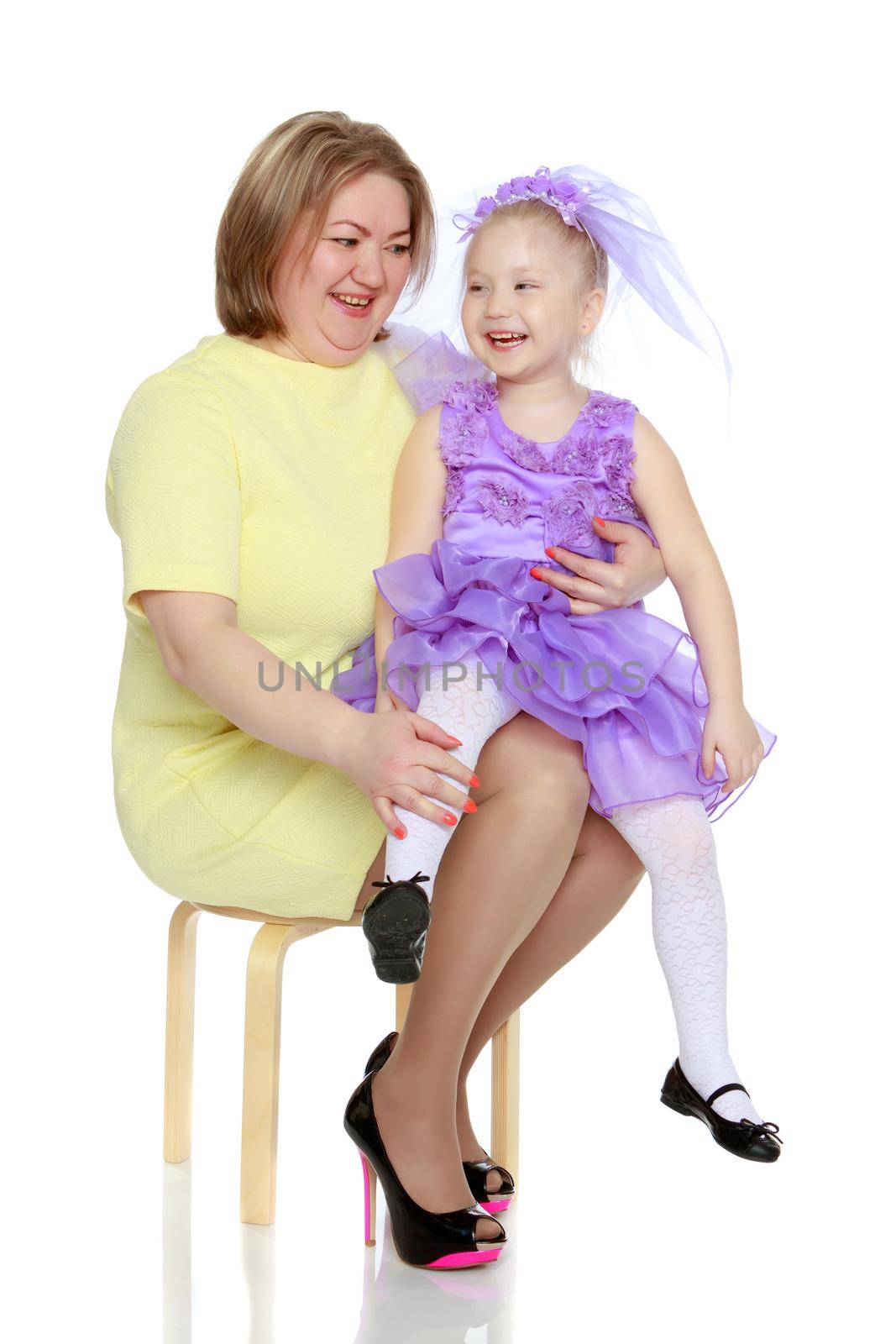 Young blonde mother, gently hugs her favorite little round-faced daughter. Family Idyll.Isolated on white background.