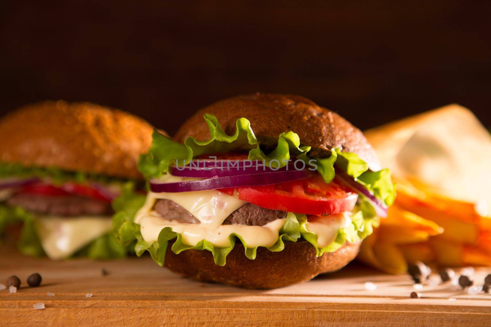 closeup of traditional cheeseburger or hamburger and french fries.