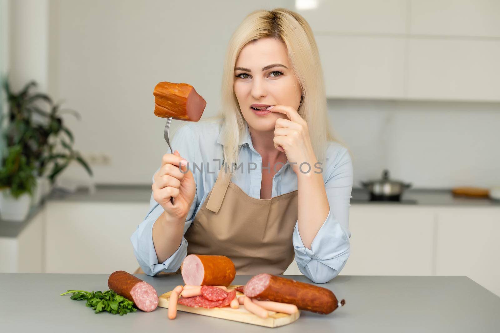 Attractive Young Woman Holding a Sausage on a Fork