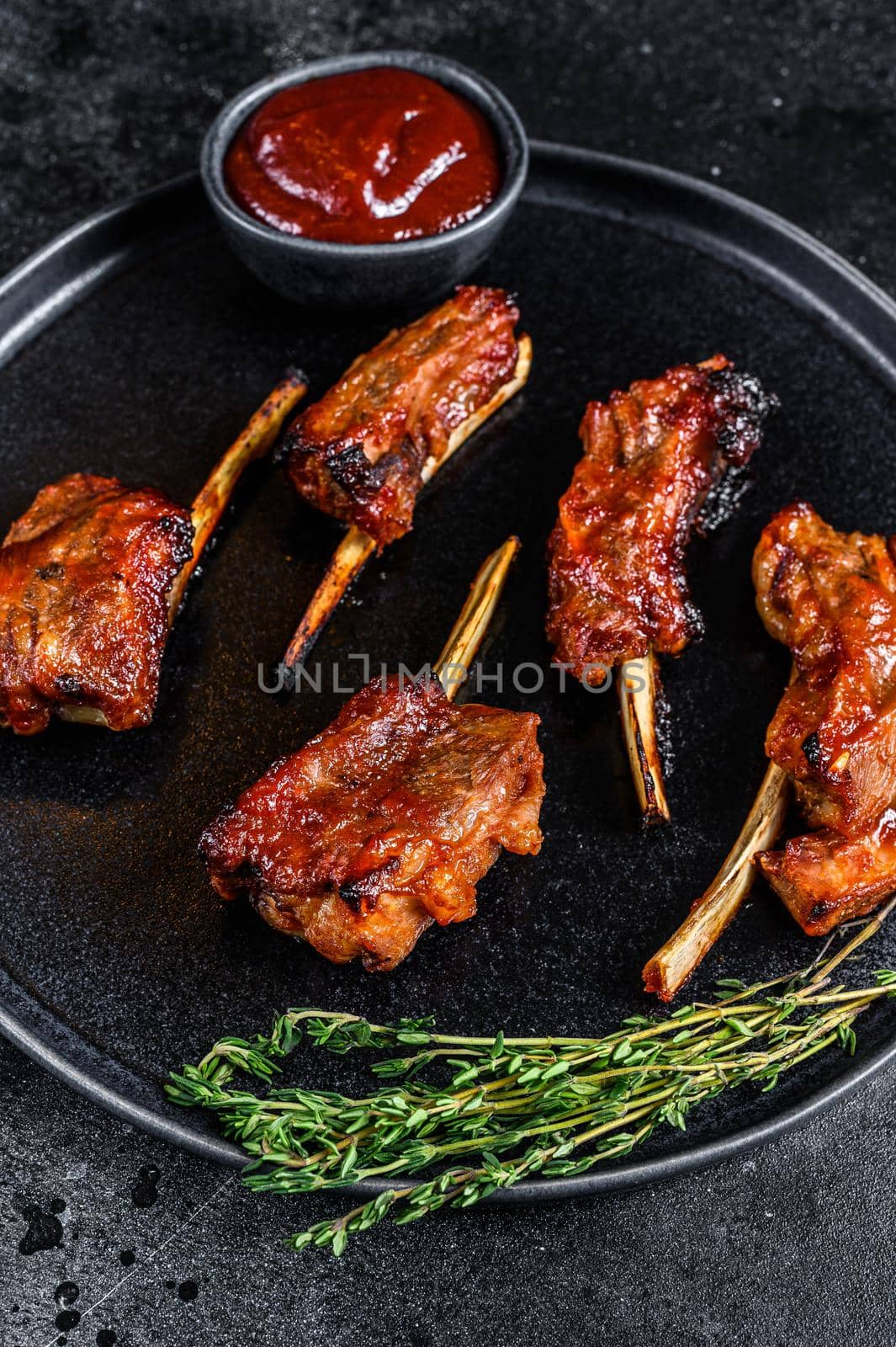 BBQ grilled sliced veal short spare loin ribs. Black background. Top view.