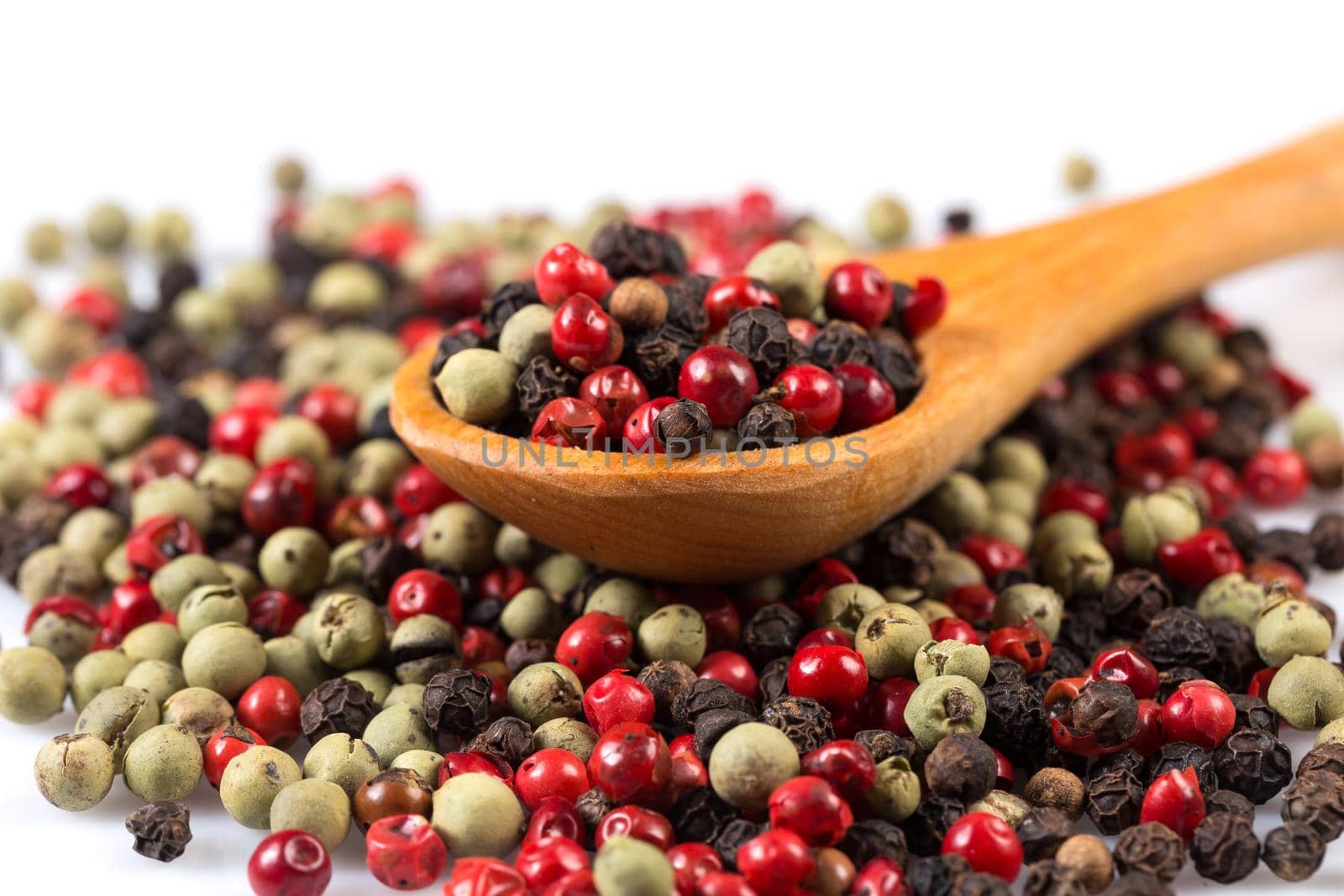 Pepper seasoning mix in wooden spoon isolated on white background cutout