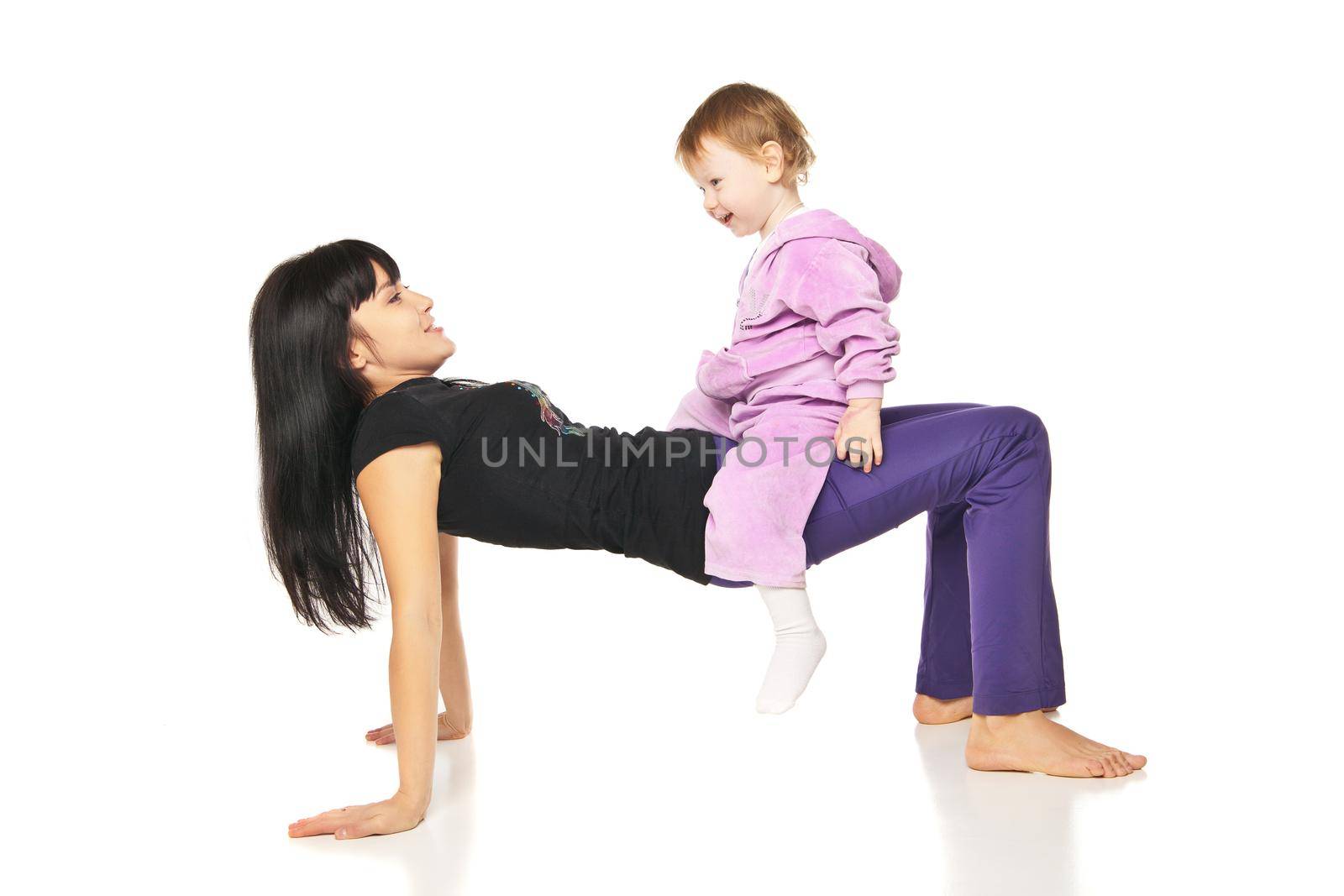 Yoga for woman and child. Mother with the baby doing exercises