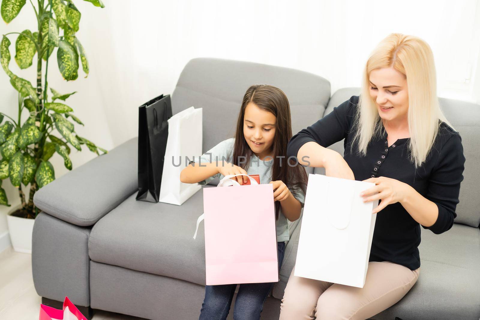 Jolly mother and her daughter having fun at home after shopping