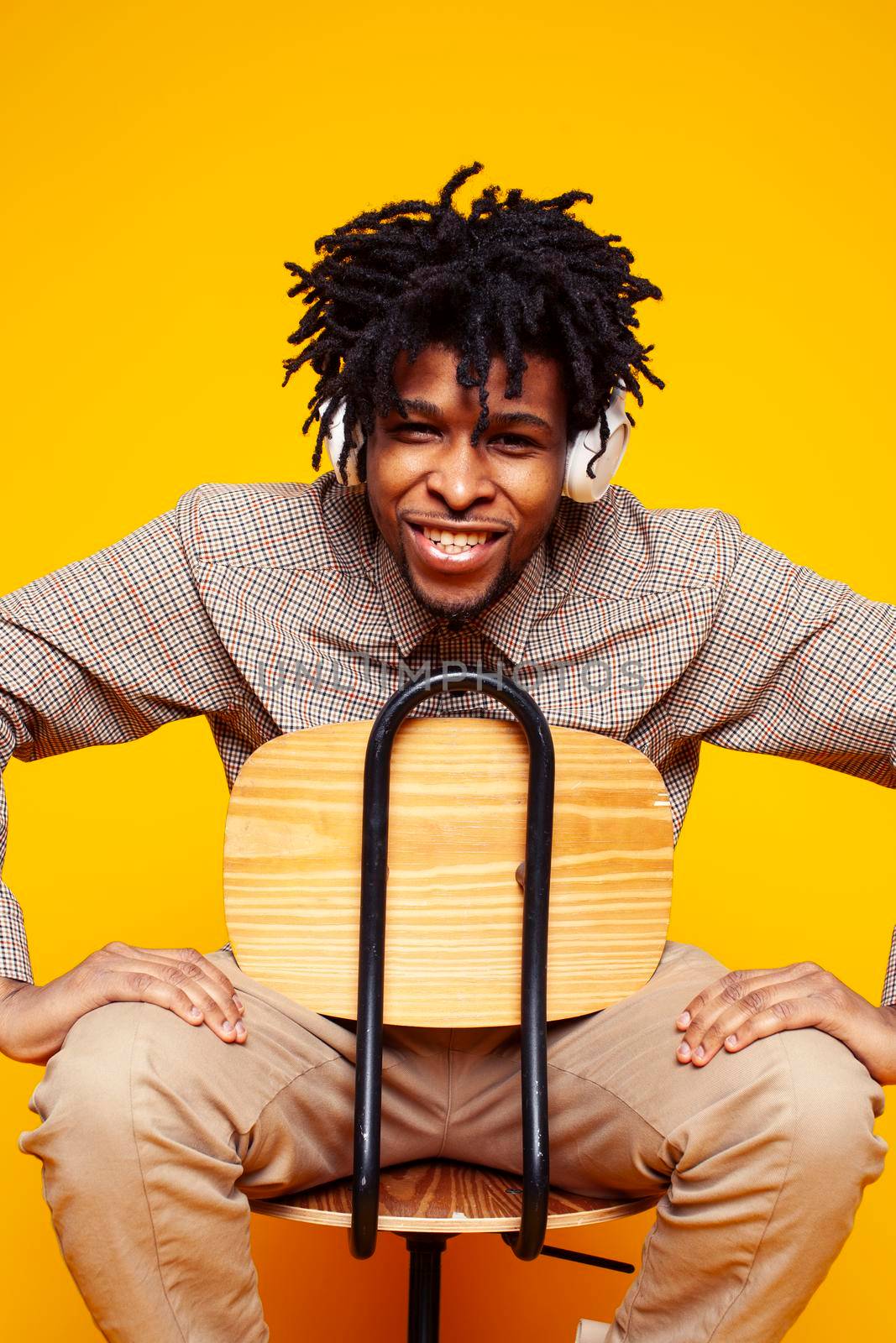 young handsome african american guy student posing cheerful and gesturing on yellow background, lifestyle people concept close up