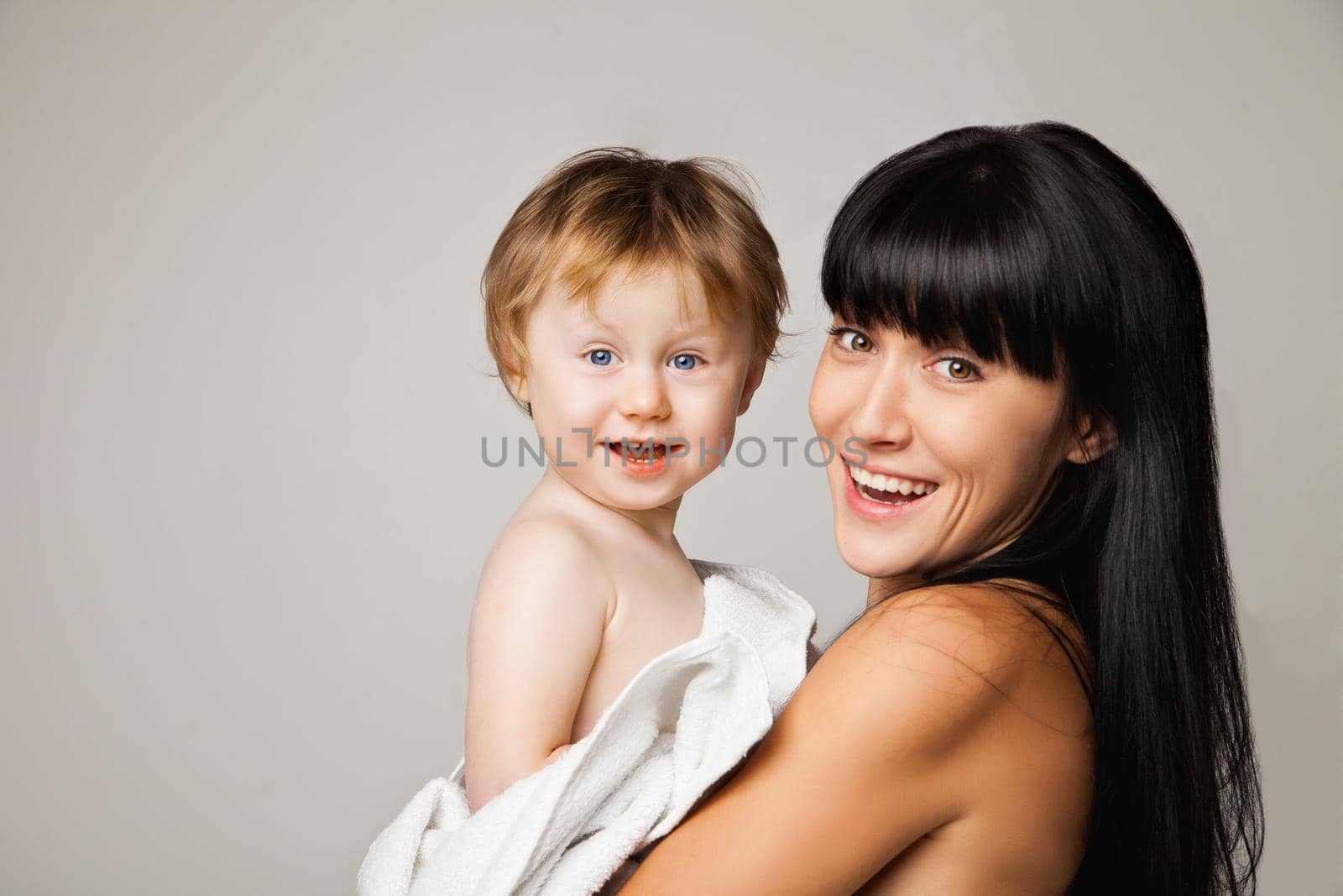 Mother with her baby after bathing in white towel by Julenochek
