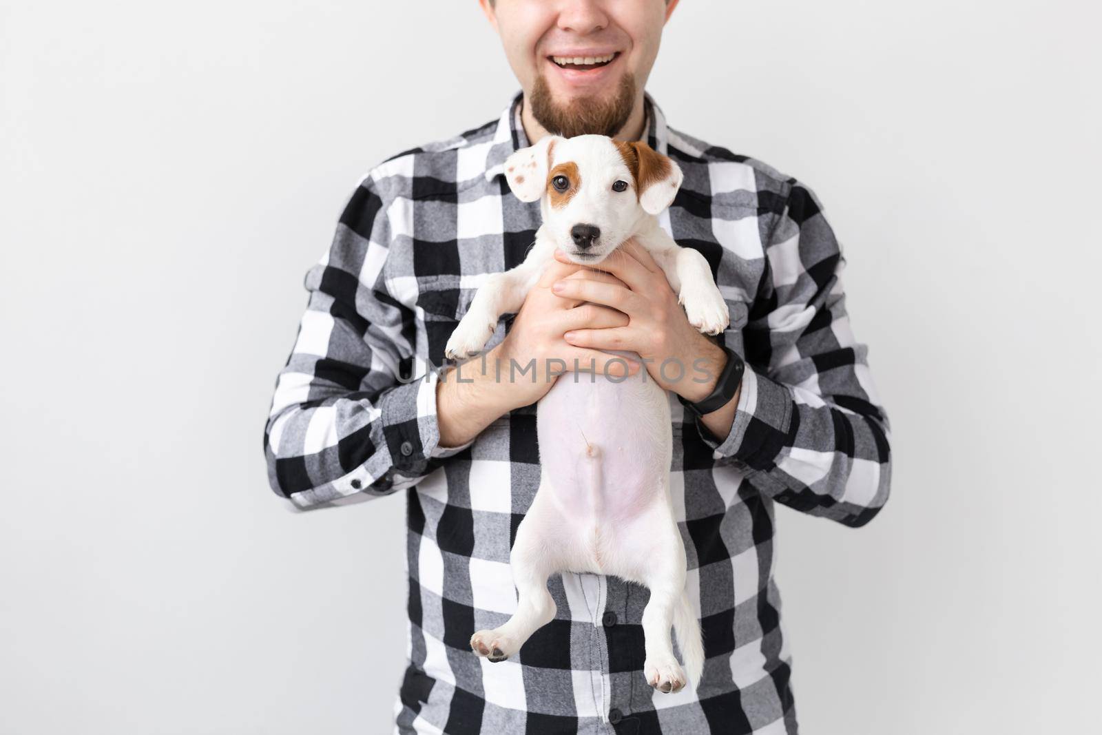 people, pets and dogs concept - close up of man hugging funny puppy on white background by Satura86