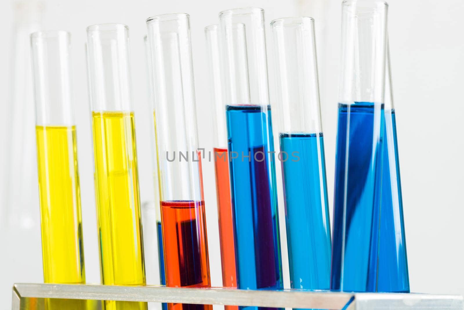 Science laboratory research and development. Close up test tubes with colorful substance on white background. Chemical manufacture concept with glass equipment. Modern biotechnology industry.