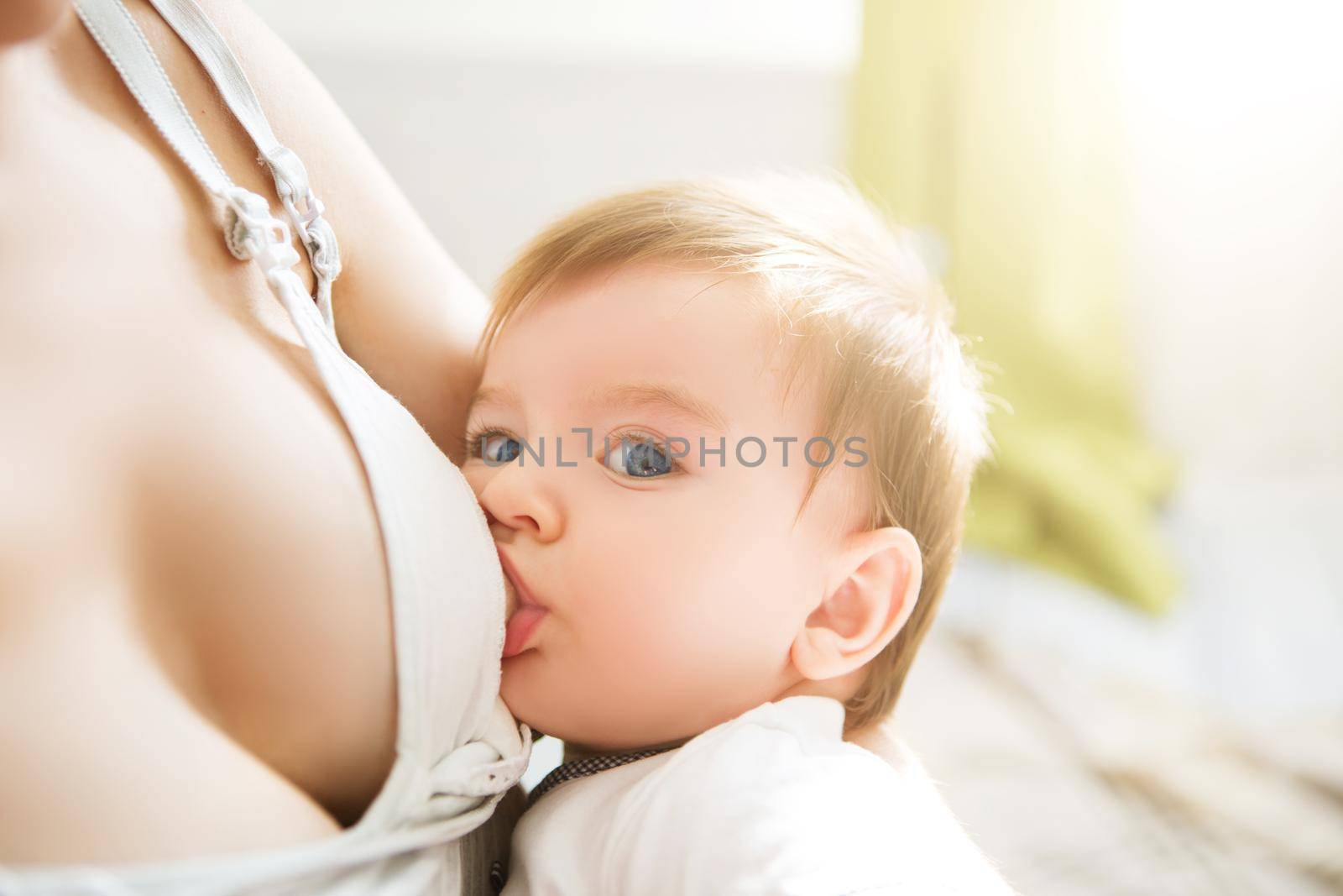 Mother breast feeding her little boy. Mom nursing and feeding baby. Close-up portrait of infant.