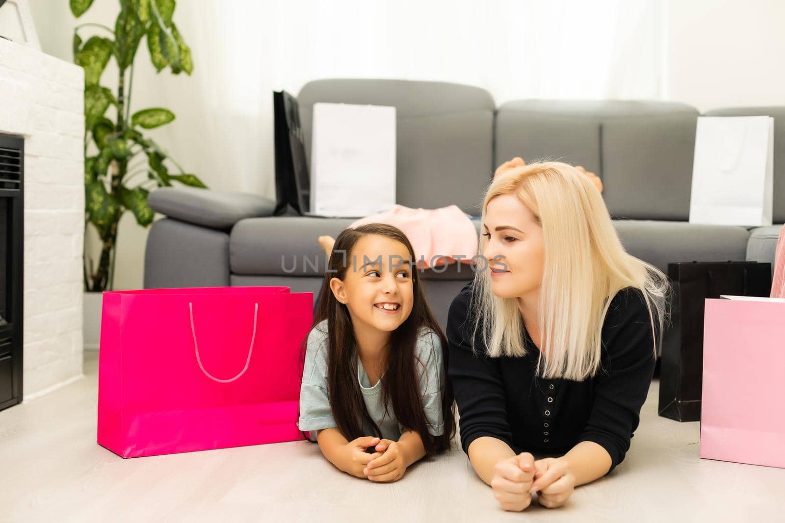 Happy Mother and daughter unpacking shopping bags in the living-room