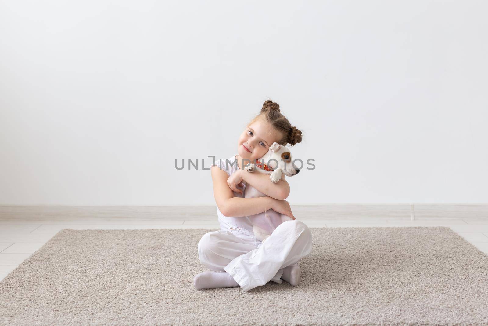 people, children and pets concept - little child girl sitting on the floor with cute puppy Jack Russell Terrier by Satura86